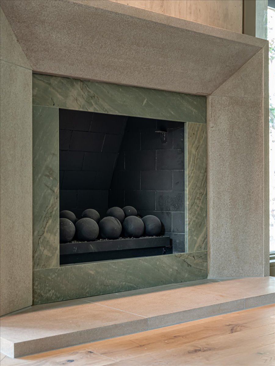 Stone fireplace featuring a green marble surround and hearth