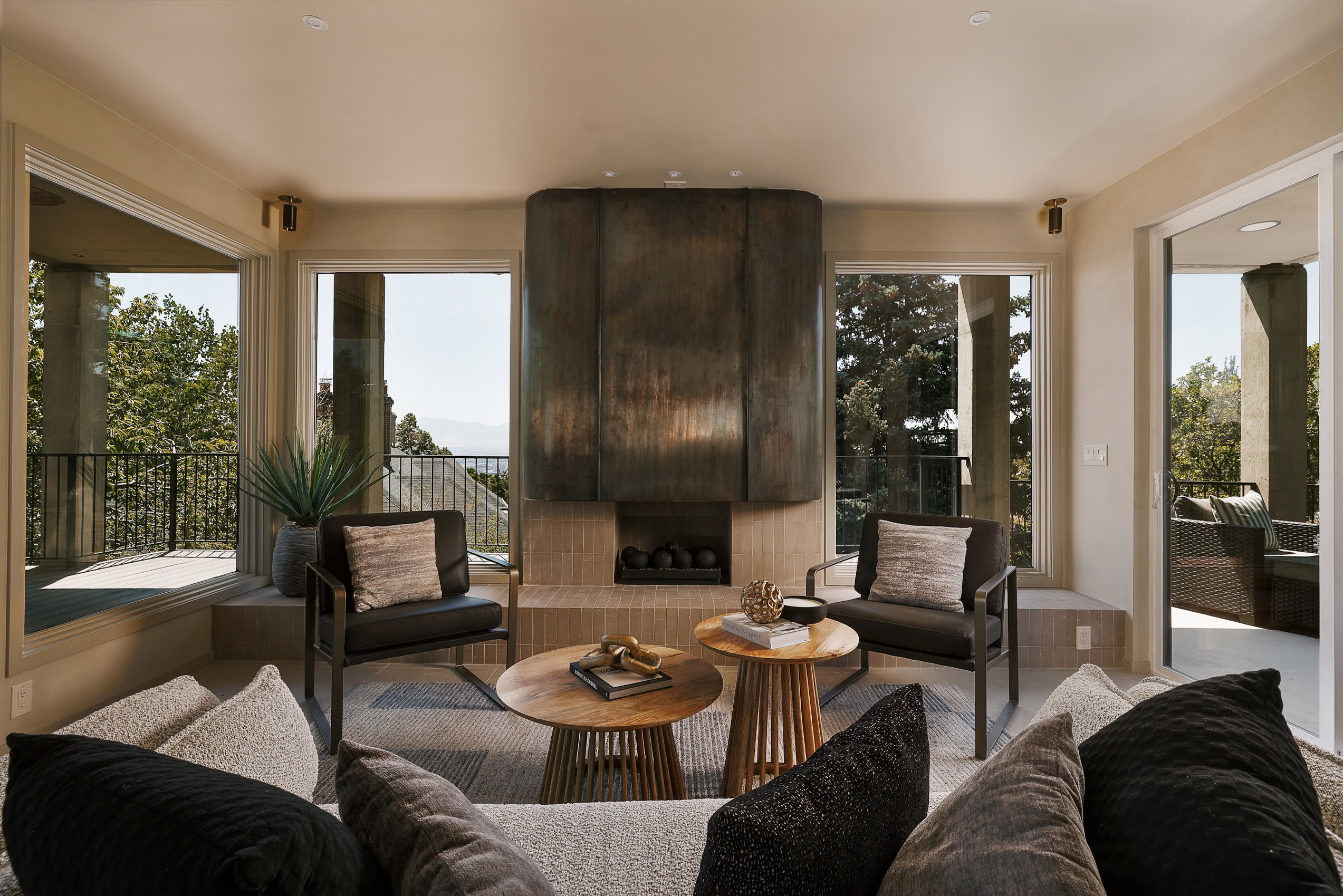 Living area featuring a floor-to-ceiling fireplace with a textured metal façade and integrated hearth
