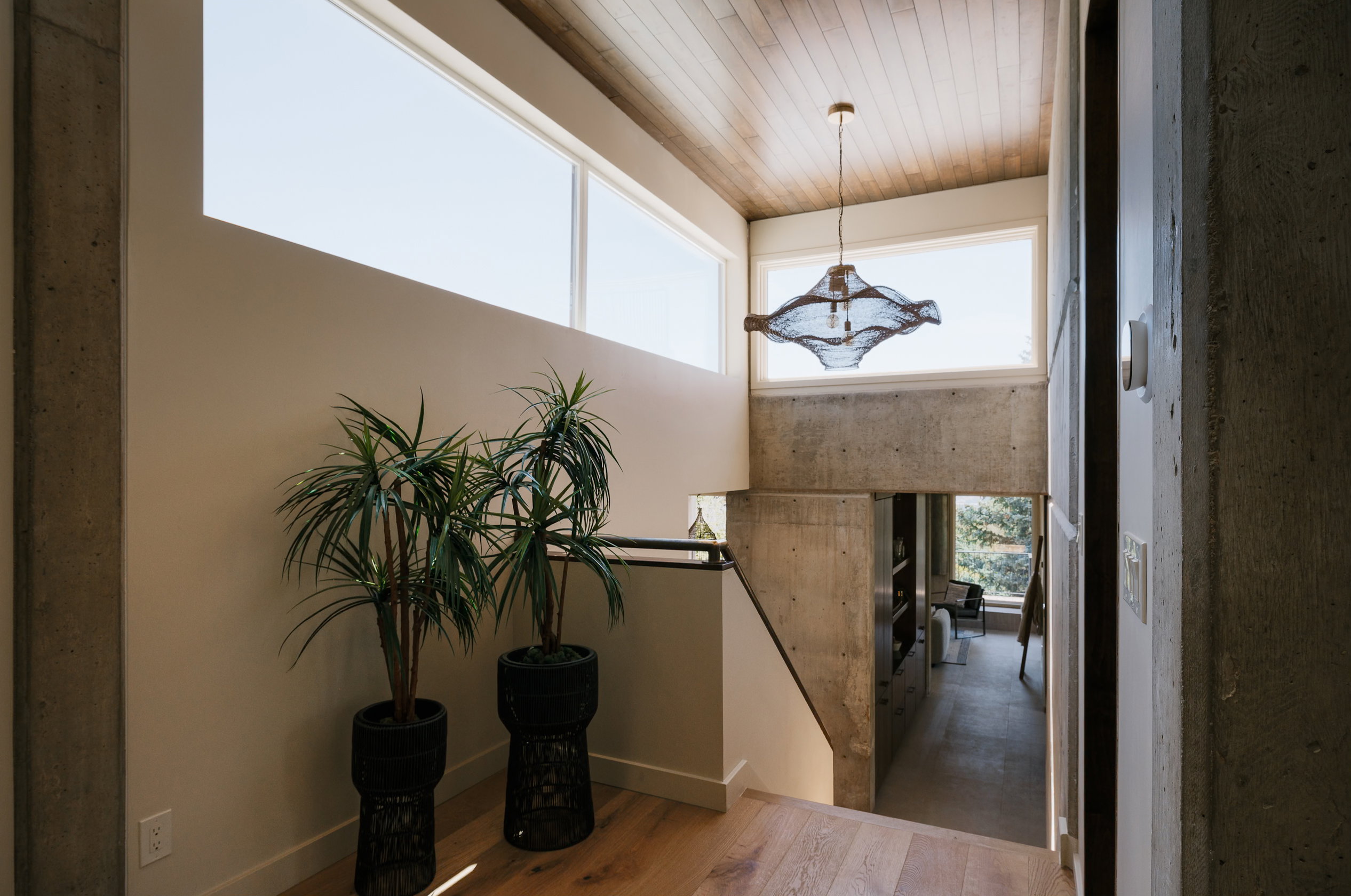 Upper-level landing featuring wood-finish flooring, a wood-paneled ceiling, and a contemporary pendant light fixture