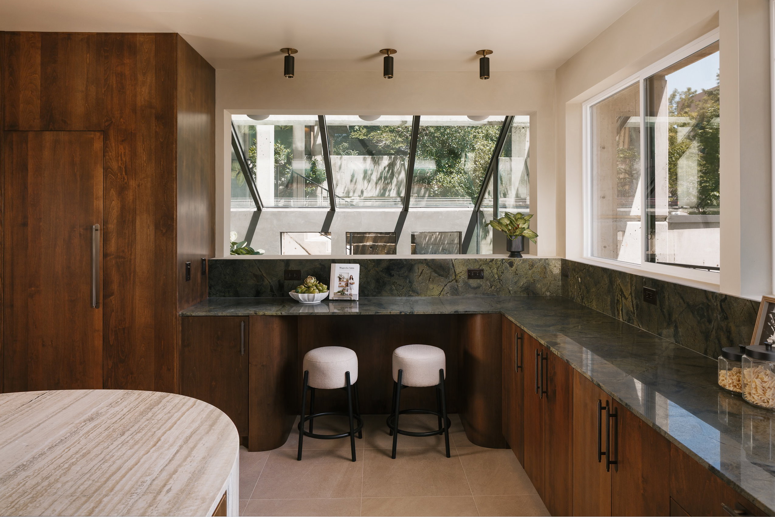 Custom wood cabinetry featuring integrated appliances and dark hardware