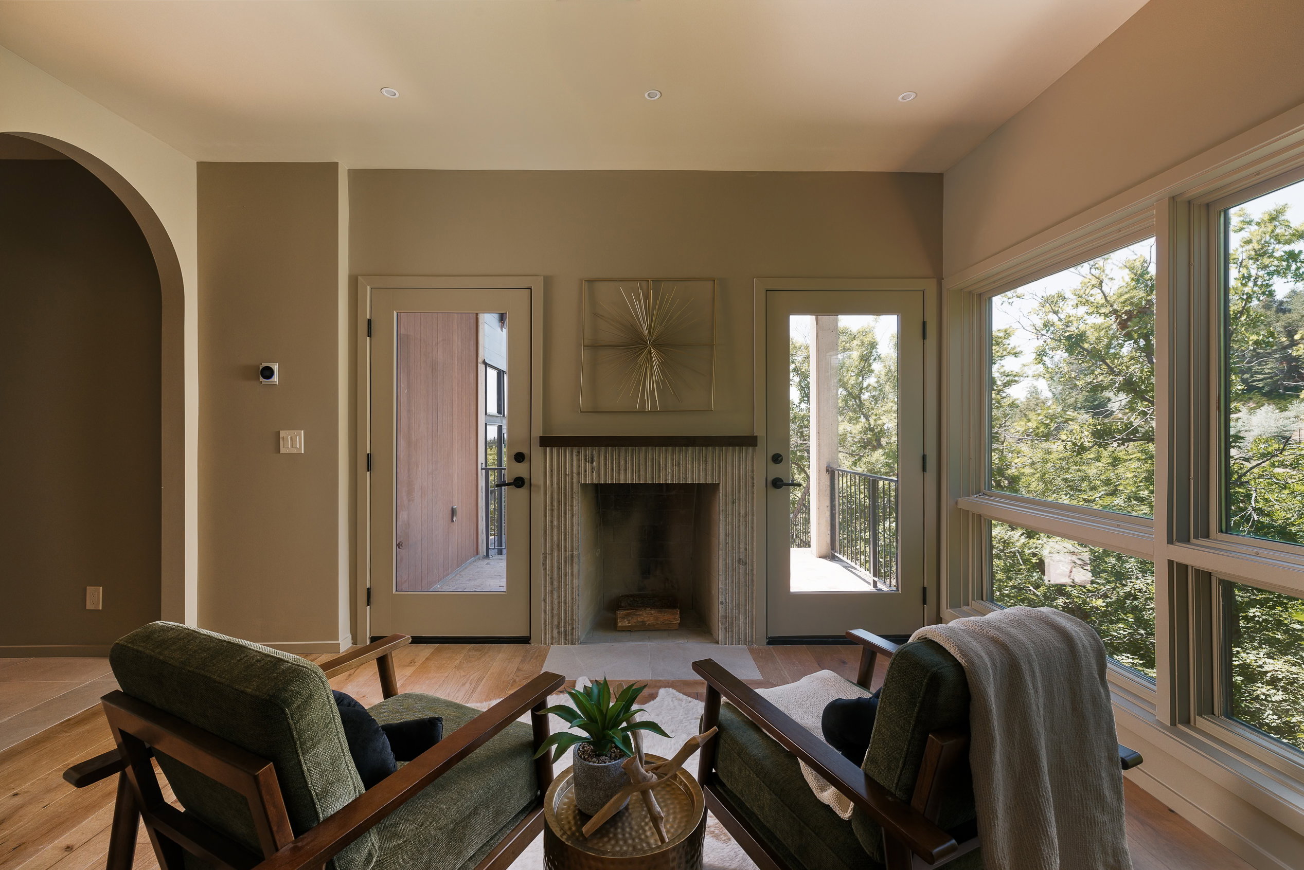 Living area featuring a fireplace with a textured surround, light flooring, recessed lighting, and a wide window-wall