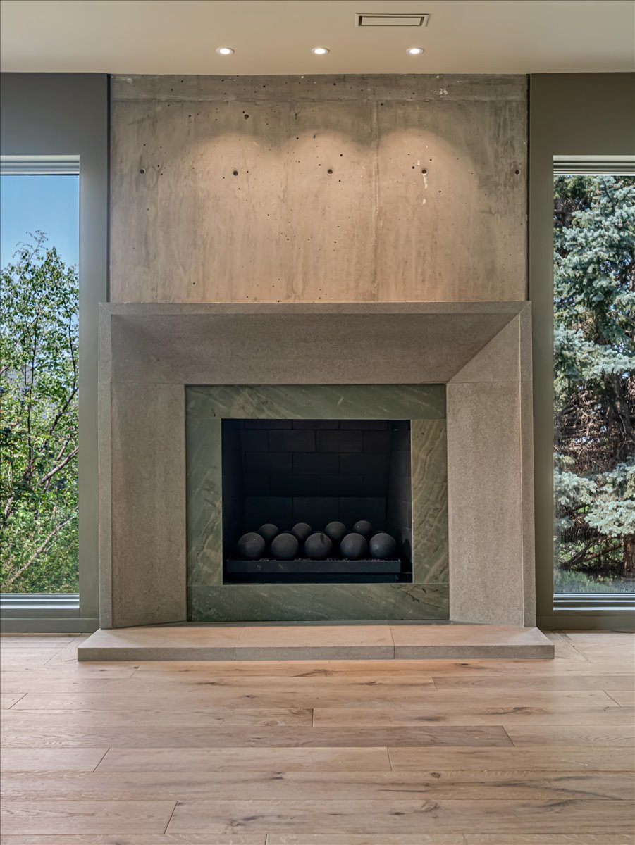 Concrete fireplace surround with recessed lighting, integrated hearth