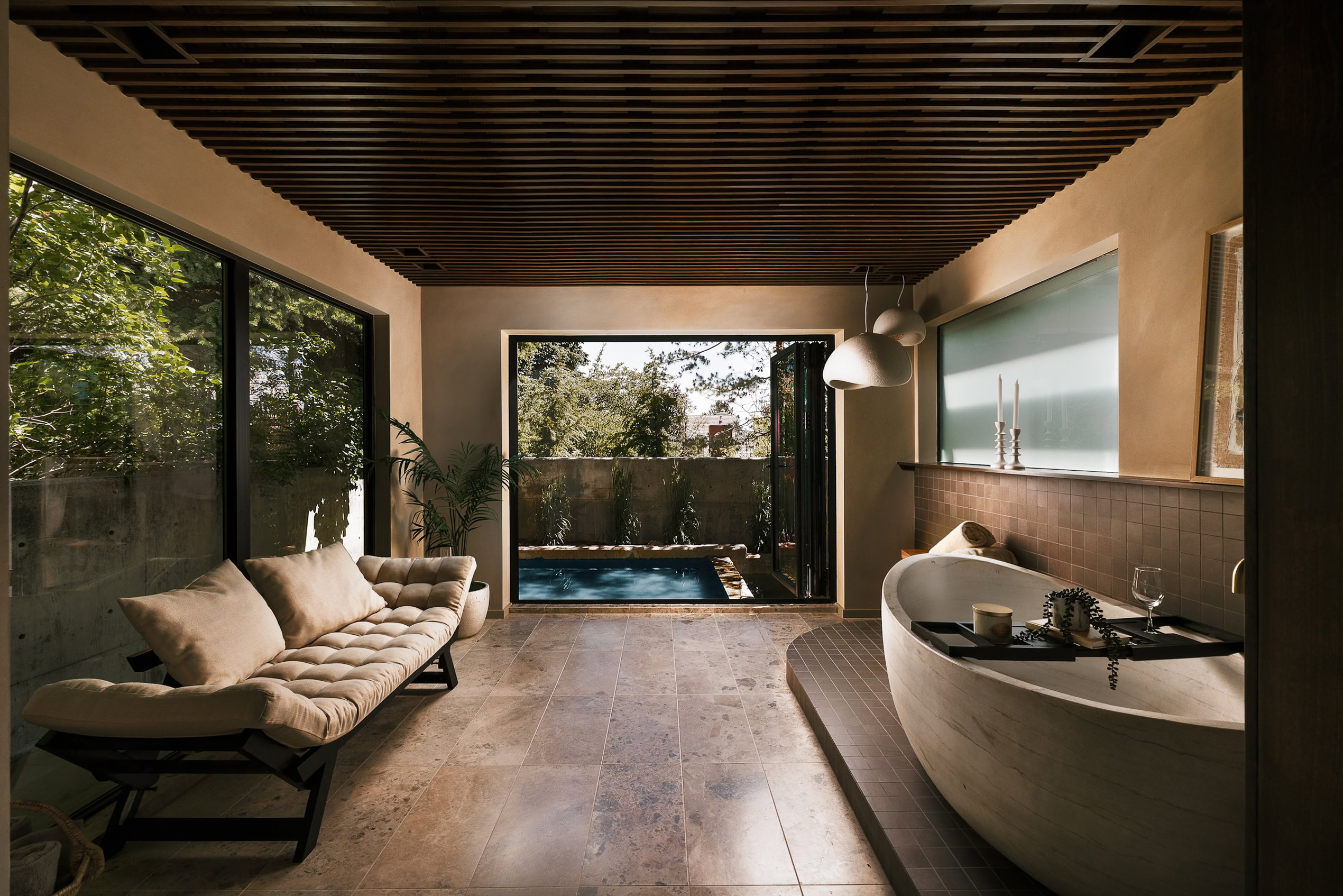 Interior space featuring a wooden slatted ceiling, stone tile flooring, and full-height glass panels