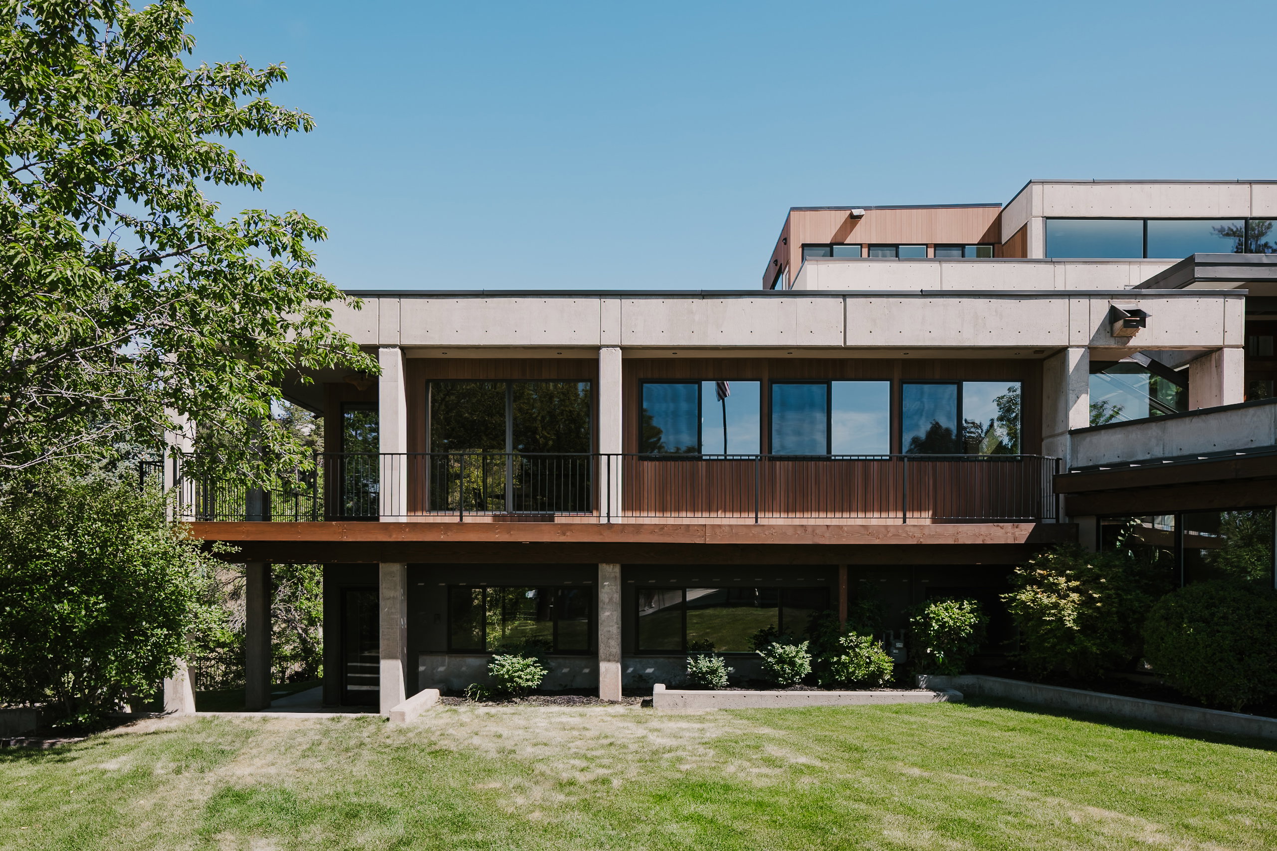Multi-level modern architectural facade featuring concrete and wood-panel accents