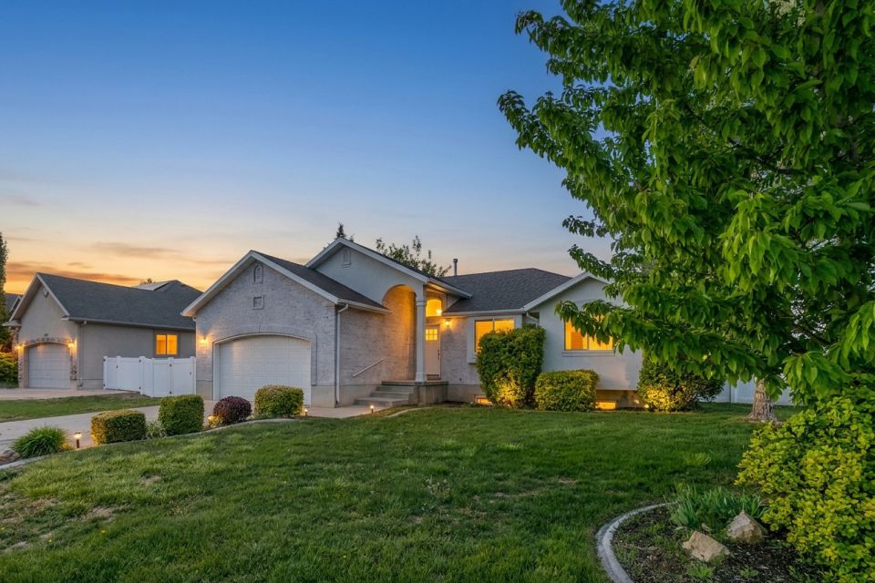 Ranch-style residence featuring a textured gray exterior, arched entry, and a two-car garage