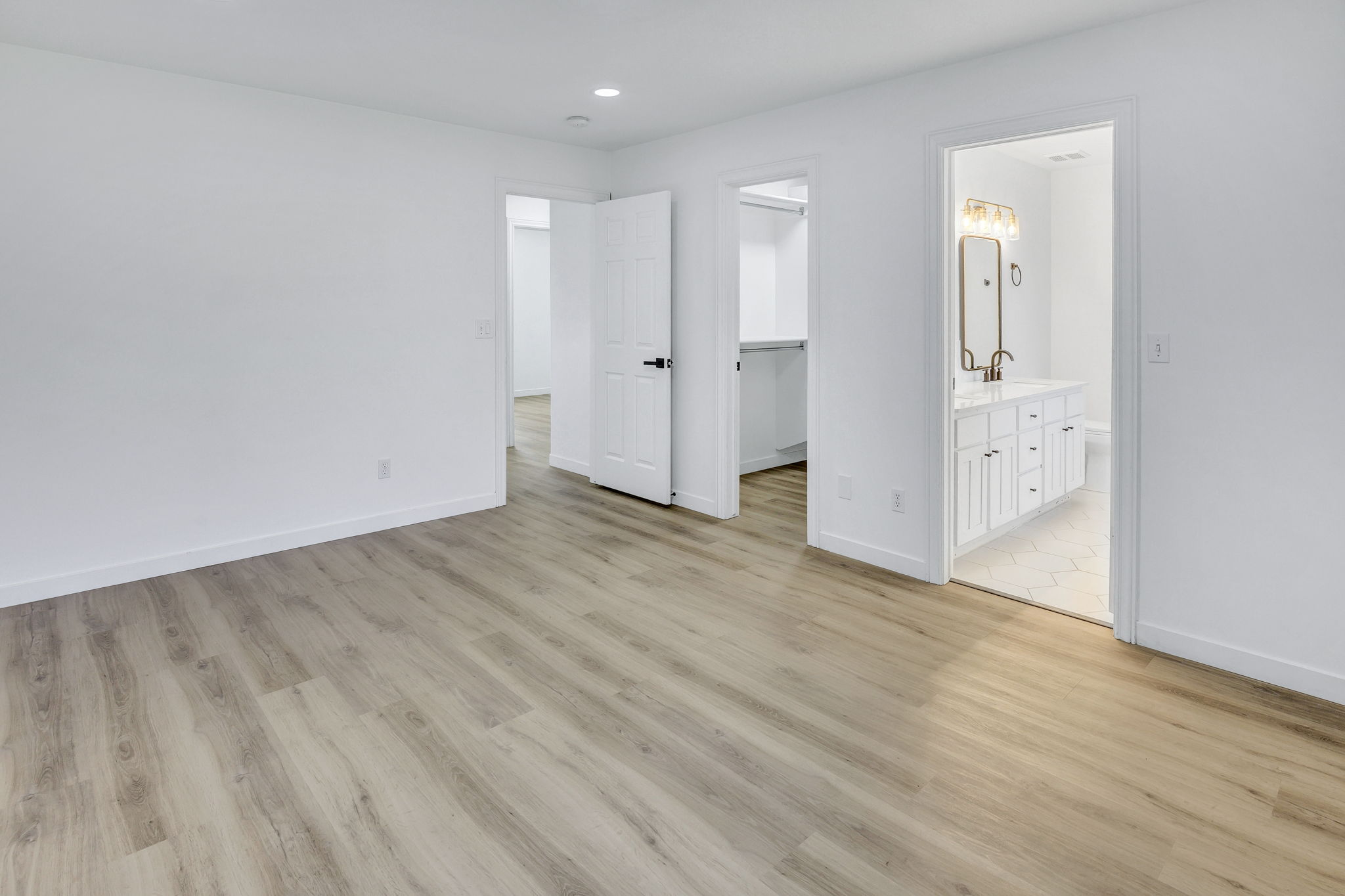 Bright interior with wood-finish flooring, white walls, and recessed lighting