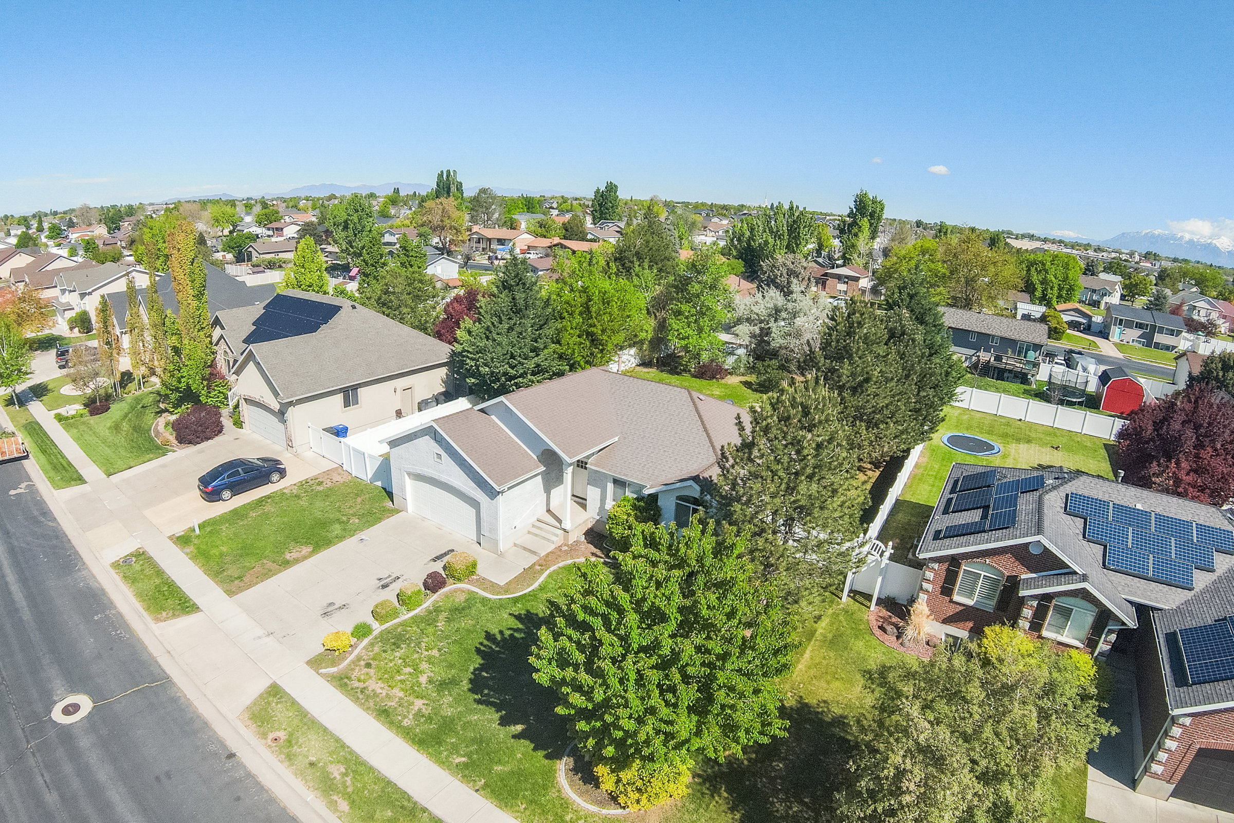 Single-story residence featuring a two-car garage, mature landscaping, and a well-maintained lawn