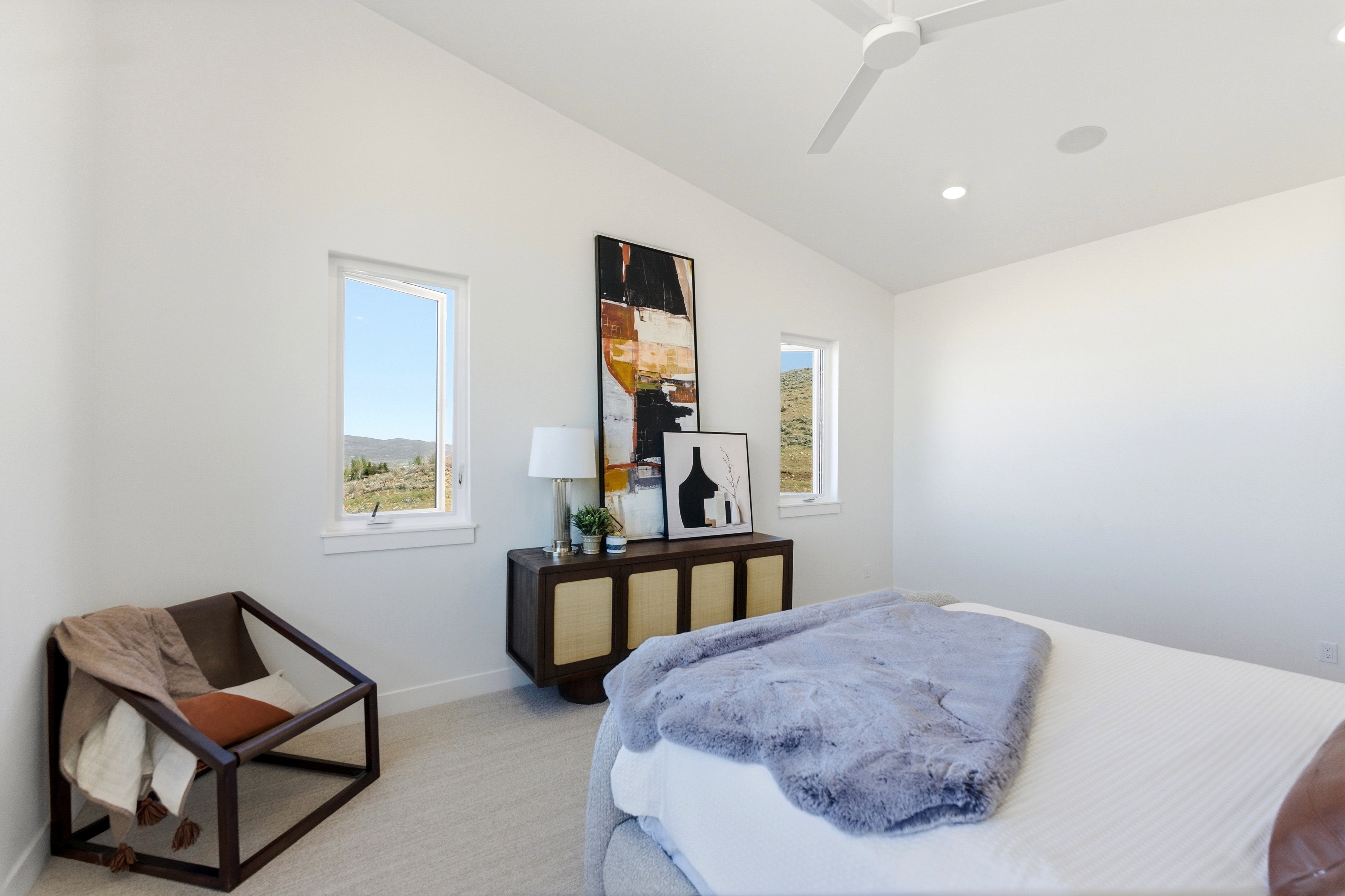 Primary bedroom with vaulted ceiling with a contemporary ceiling fan and recessed lighting