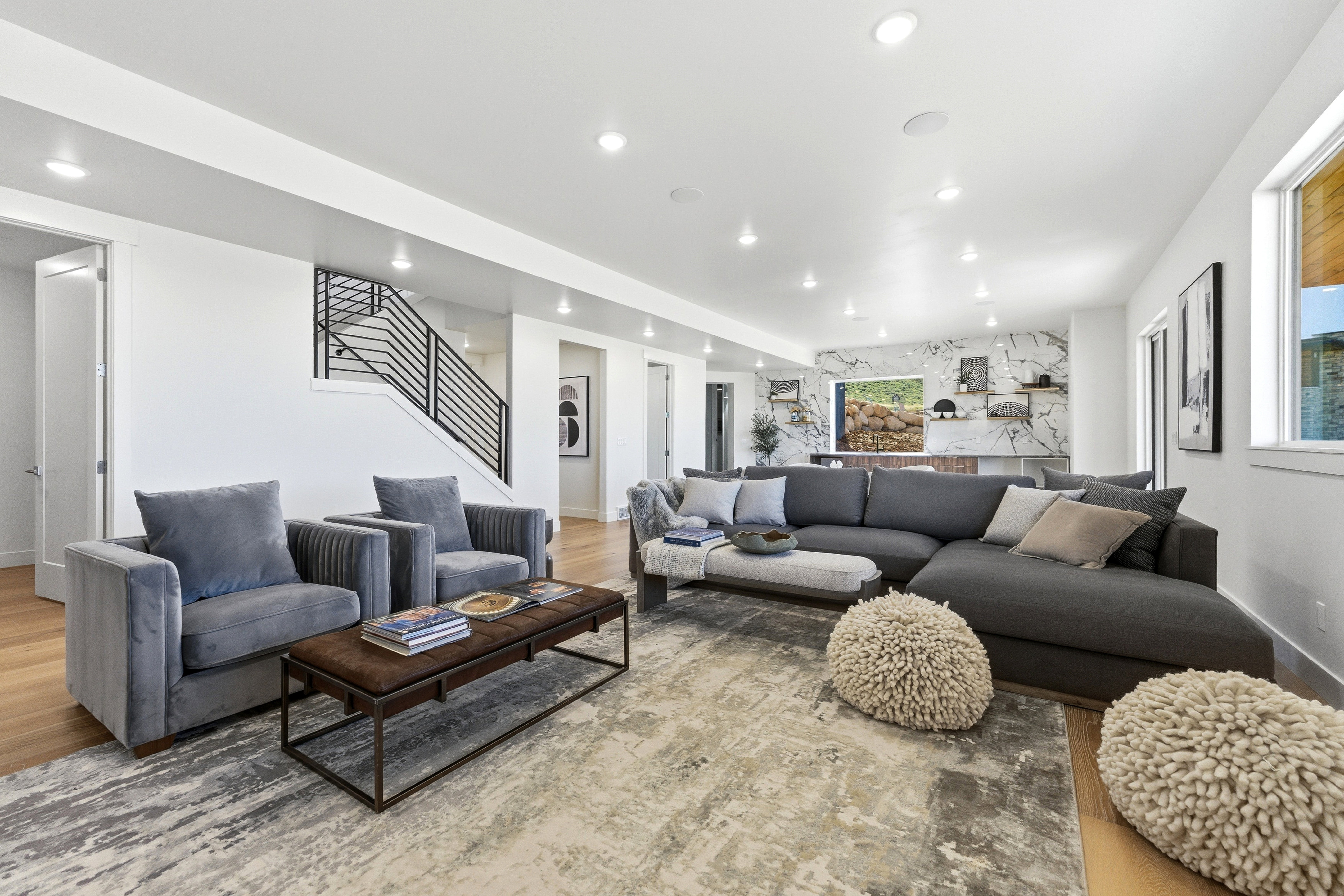 Spacious living area featuring light wood-finish flooring and recessed lighting