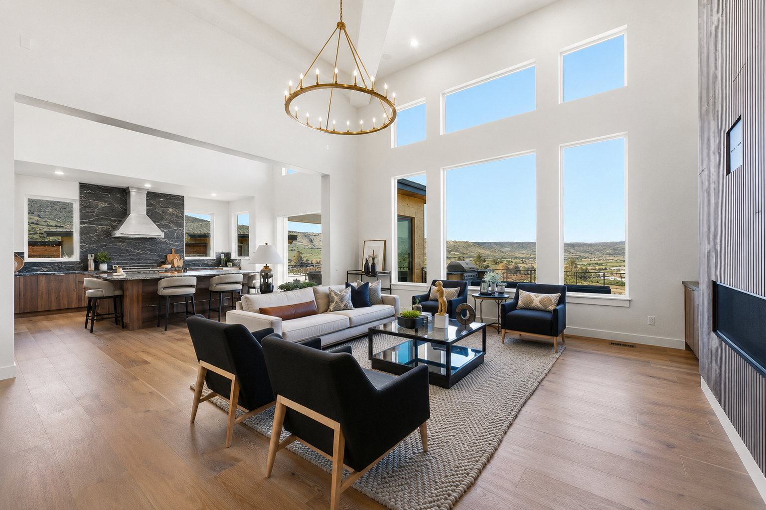 High ceilings with a prominent chandelier and expansive windows featuring distant mountain scenery