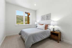 Bright room featuring a large window, recessed lighting, neutral wall paint, white trim, and light-toned carpet flooring