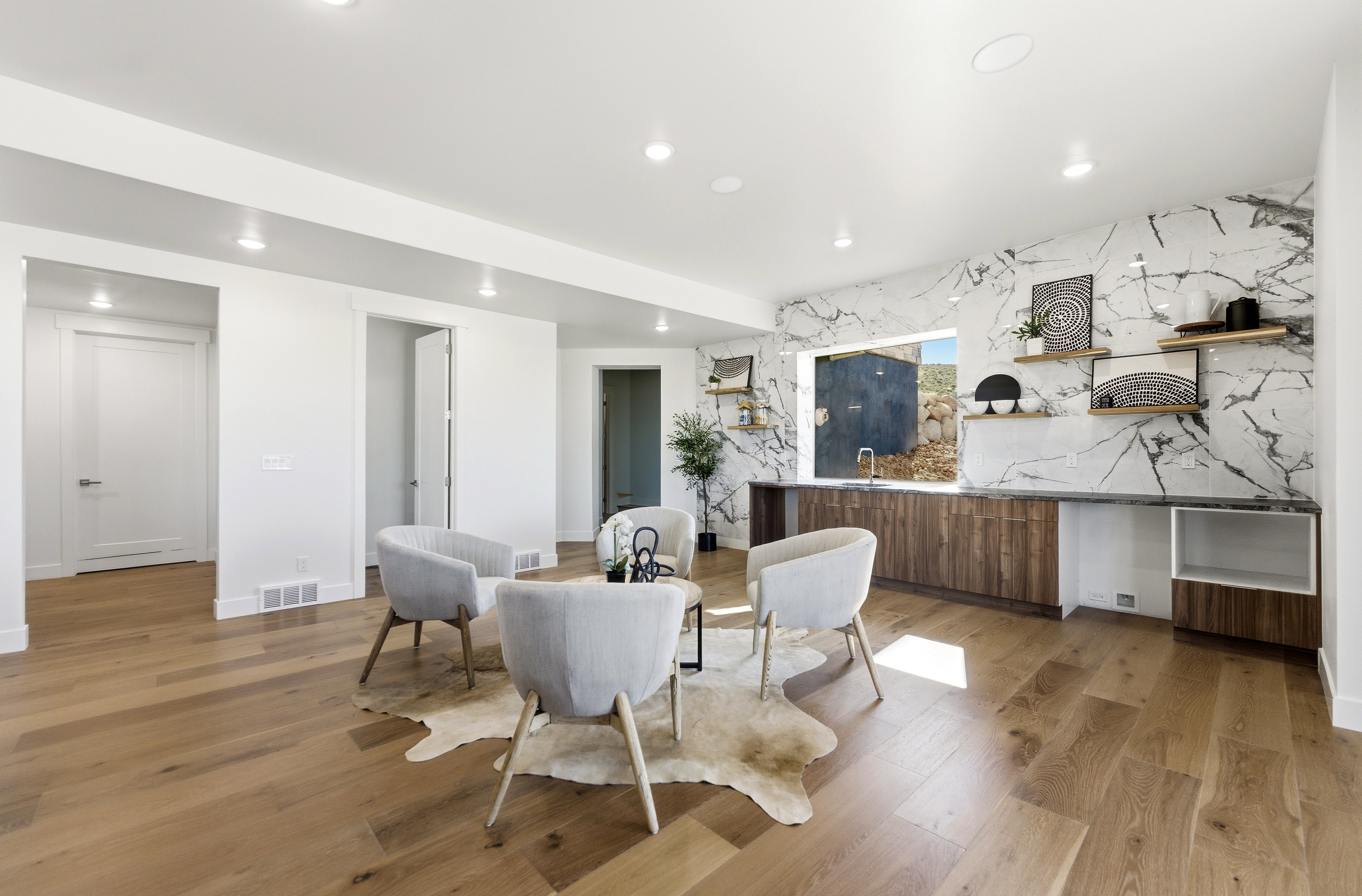 Spacious room featuring wide plank wood-finish flooring, recessed lighting, and white baseboards