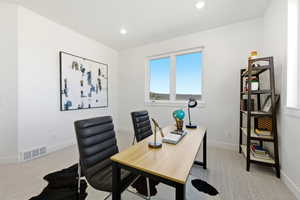 Bright room featuring a large window, recessed lighting, light-colored carpet, and white baseboards