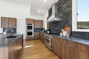 Contemporary kitchen featuring rich wood-finish cabinetry and dark patterned countertops