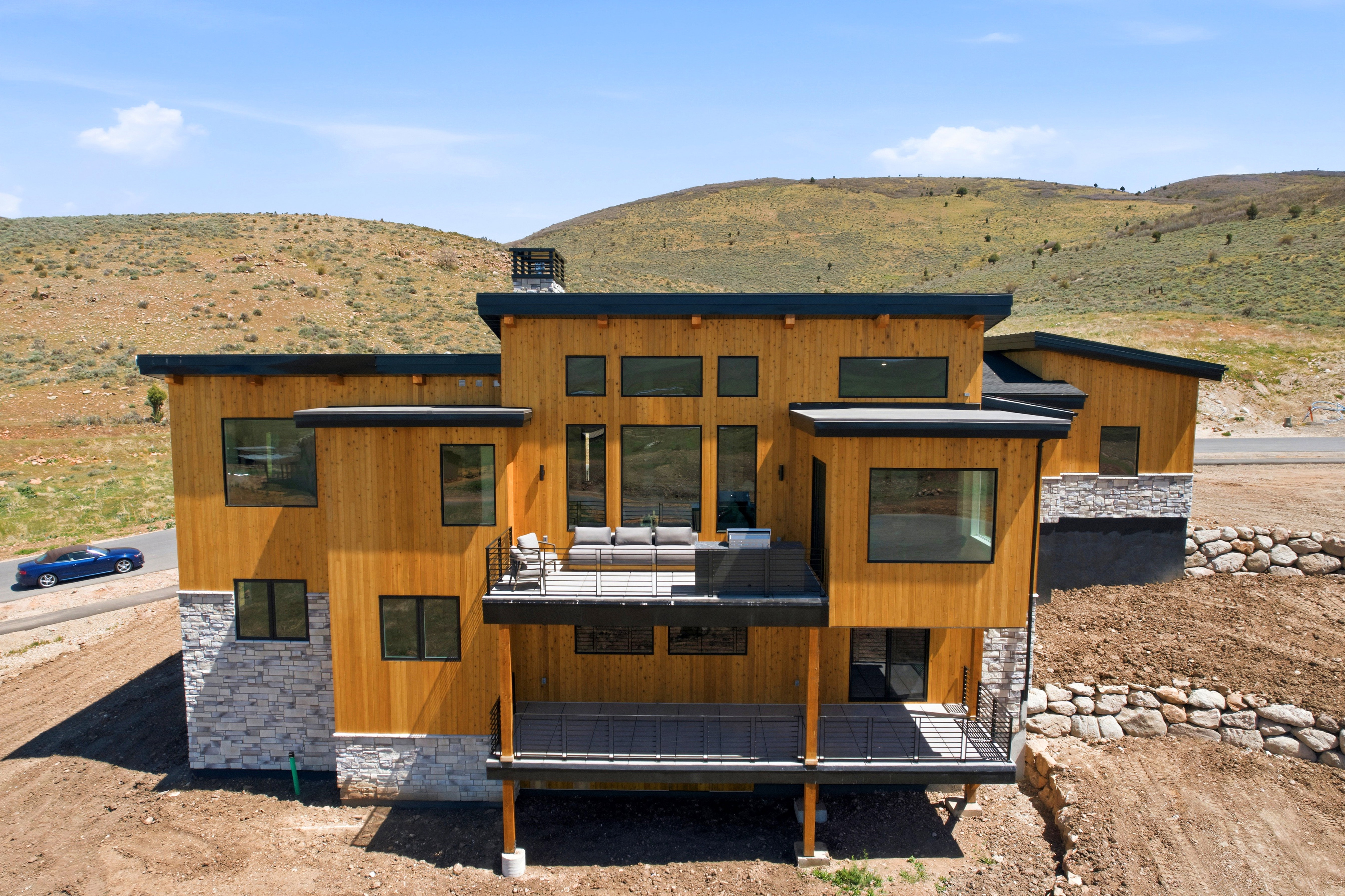 Contemporary multi-level residence featuring natural wood siding and stone veneer accents