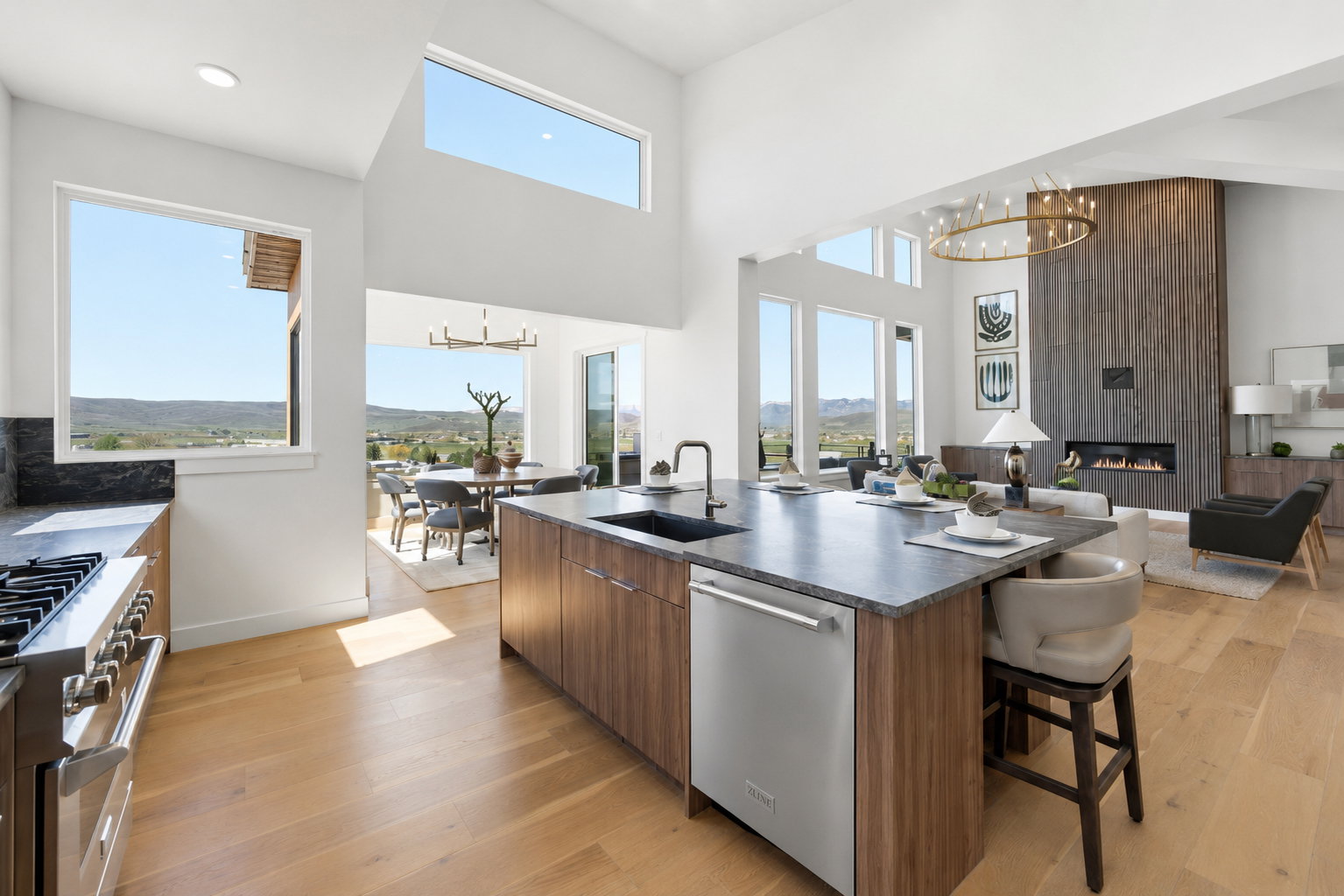 Open-concept living space featuring high ceilings, wood-finish flooring, and multiple large windows
