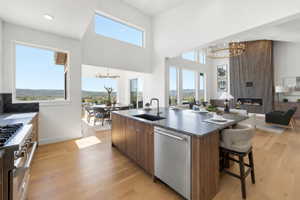 Open-concept living space featuring high ceilings, wood-finish flooring, and multiple large windows