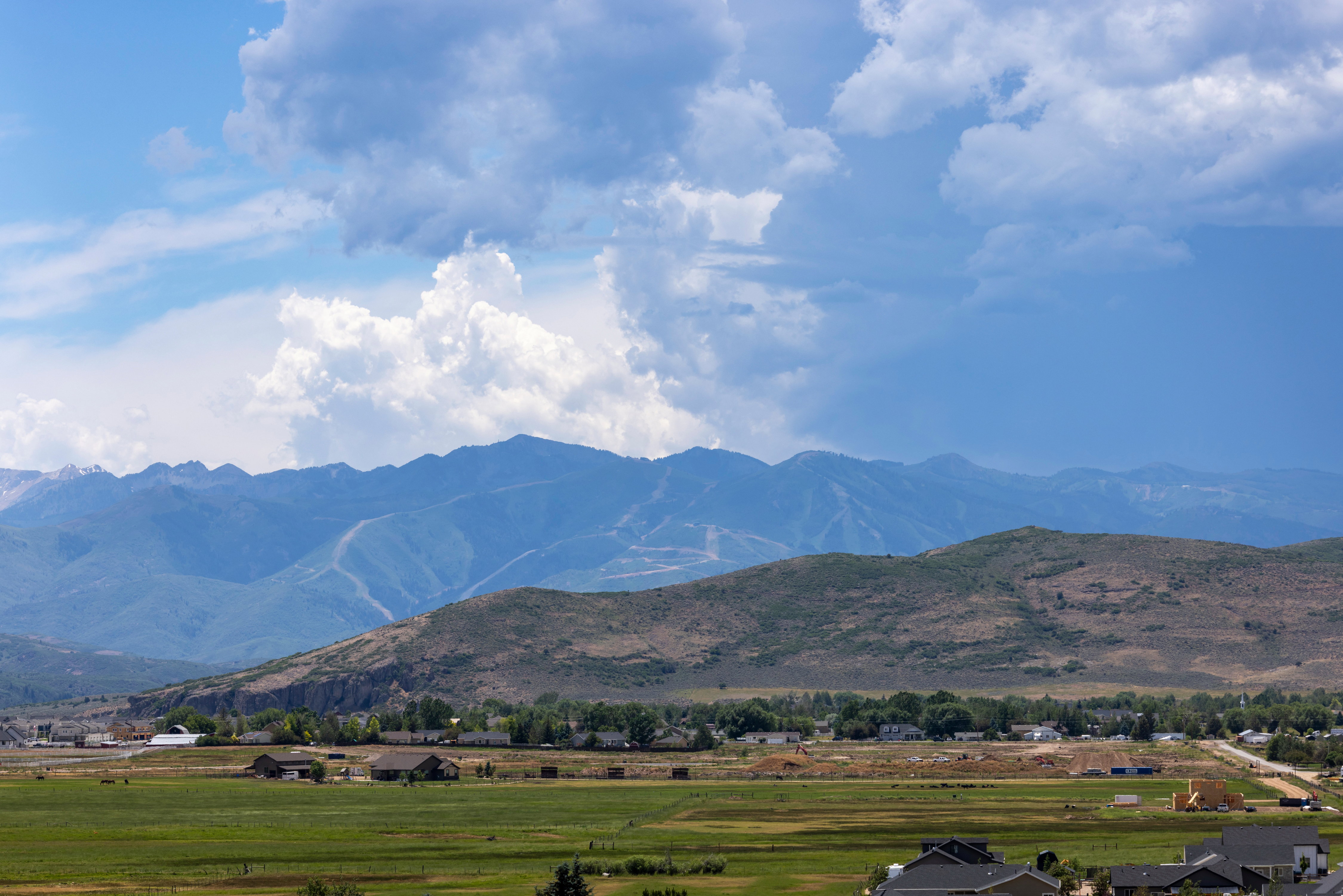 Expansive mountain range backdrop with partial snow caps