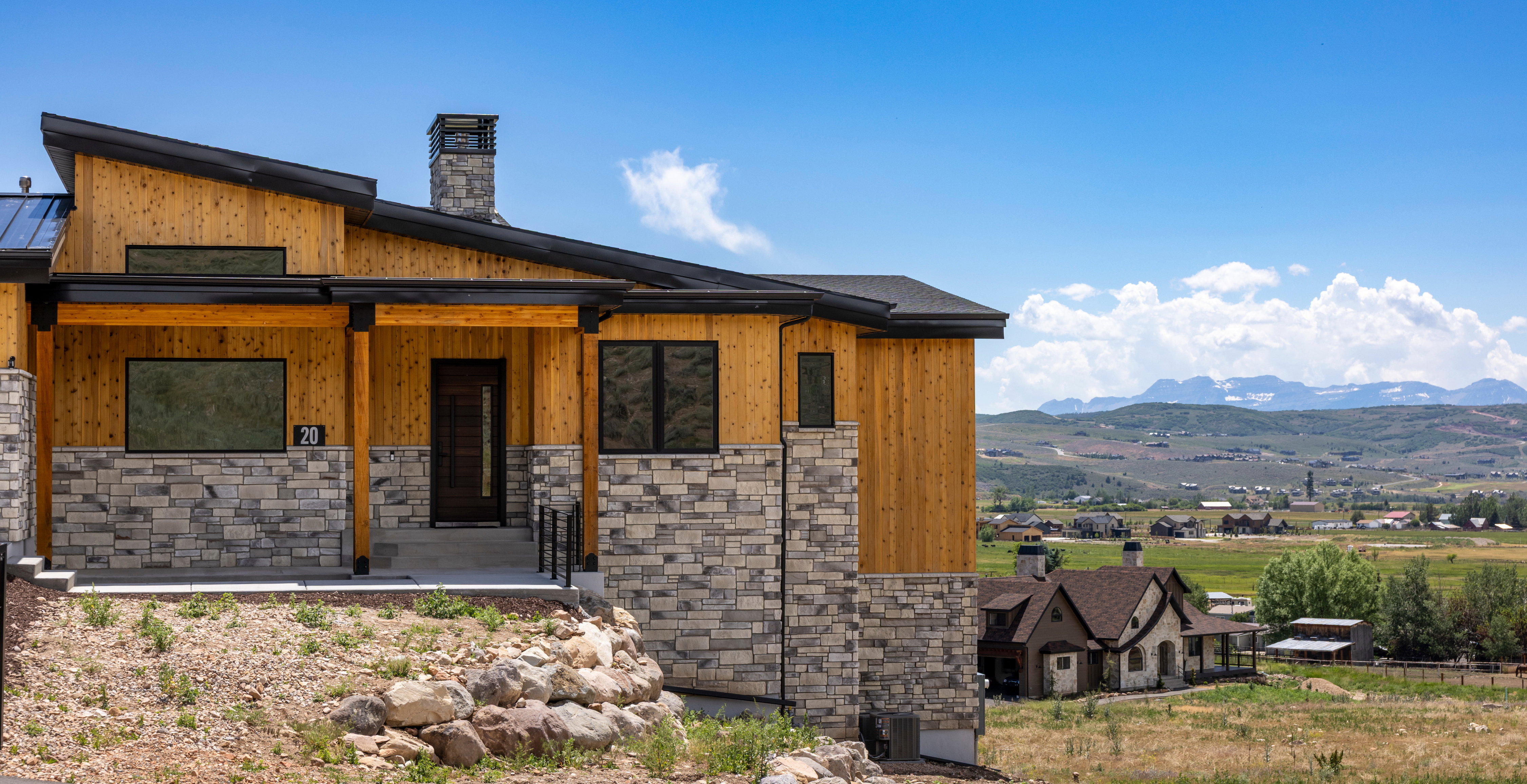 Contemporary exterior showcasing wood paneling and stone veneer