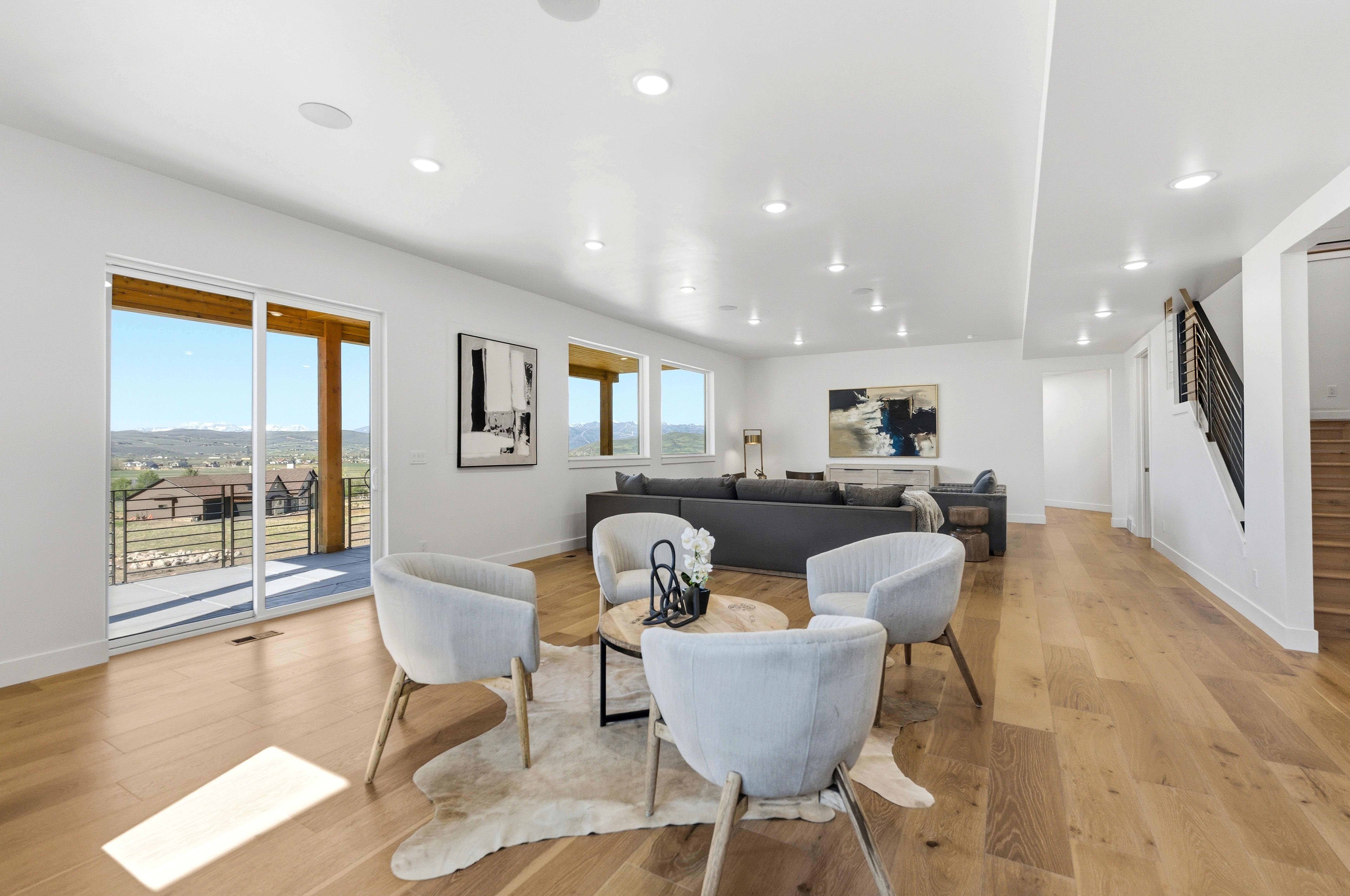 Spacious open-concept living area featuring wood-finish flooring, recessed lighting, and white walls