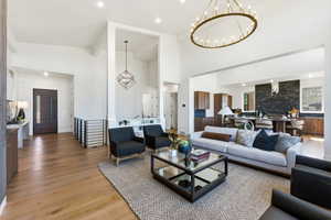 Living area featuring high ceilings, wood-finish flooring, and recessed lighting