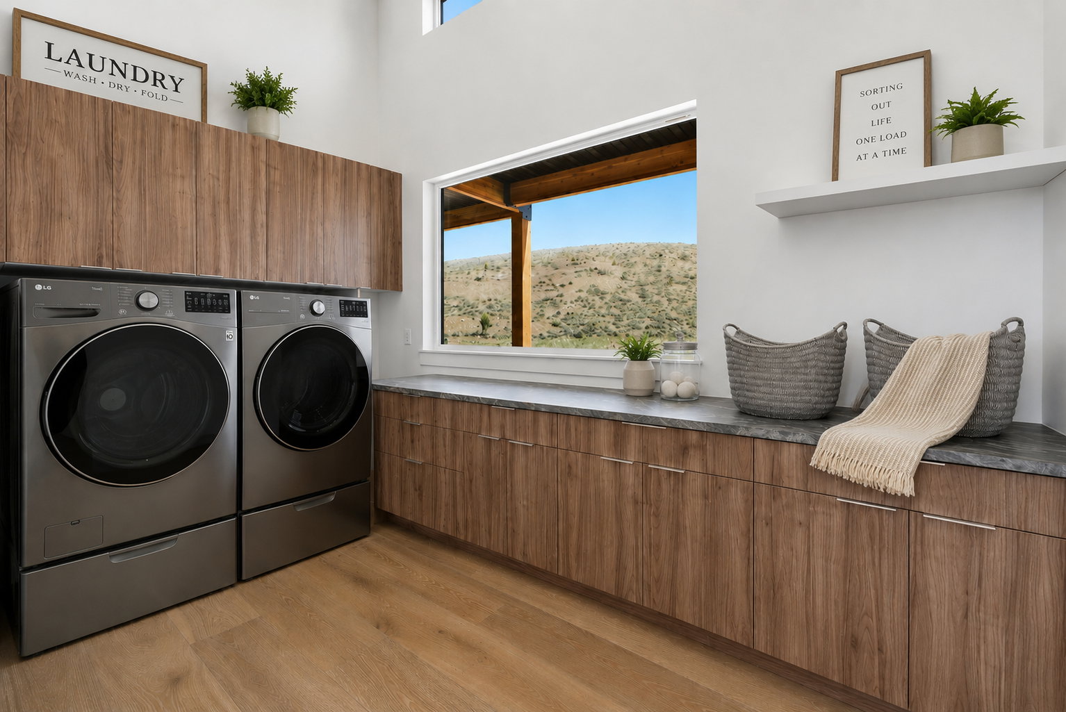 Spacious laundry area featuring wood-finish flooring, extensive cabinetry with a stone-finish countertop, and a large window virtually stages with washer and dryer