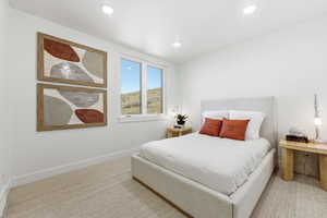 Recessed ceiling lighting illuminates a room with light-toned carpet flooring and white walls
