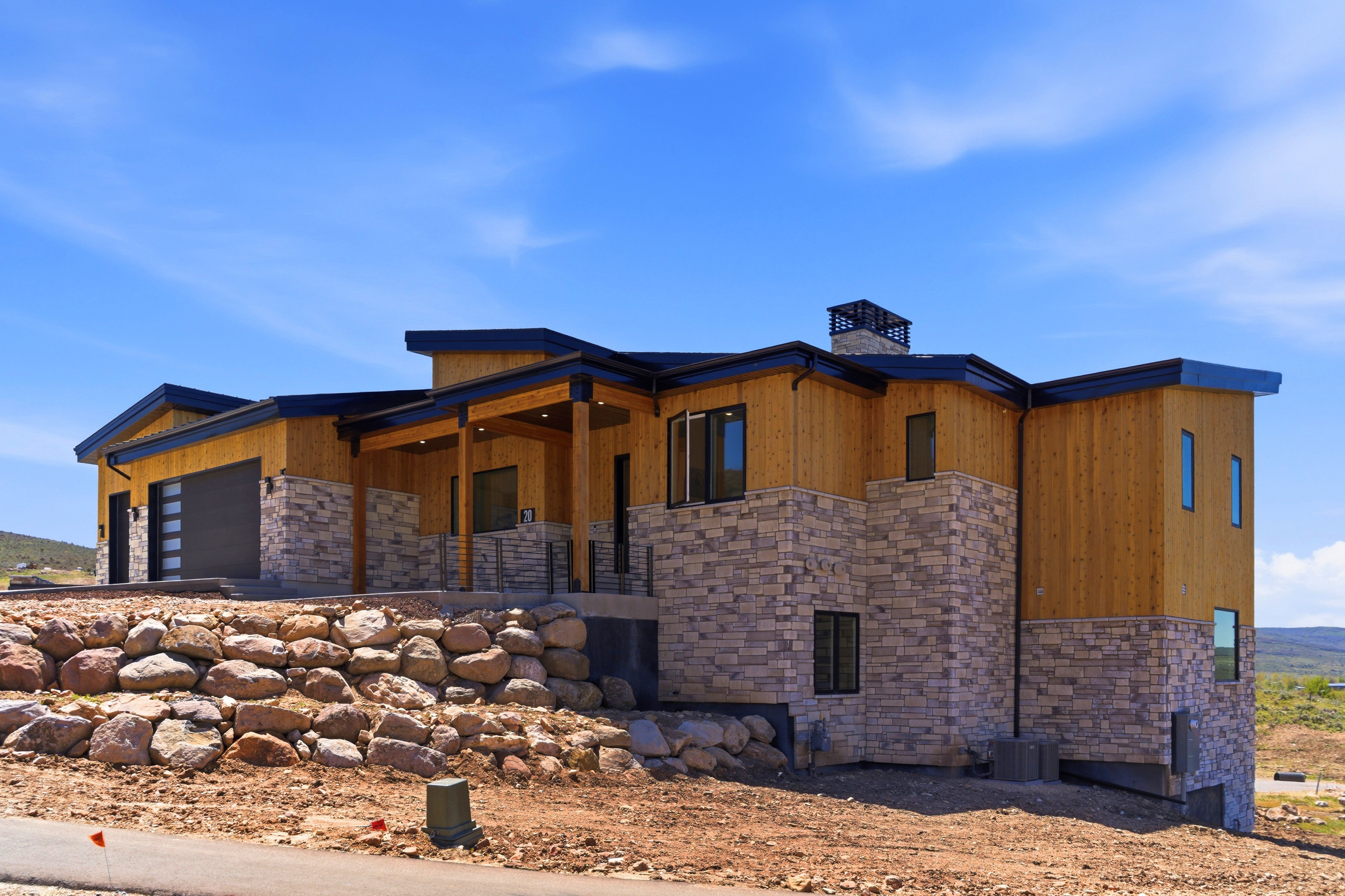 Modern architectural exterior featuring wood siding and stone masonry accents