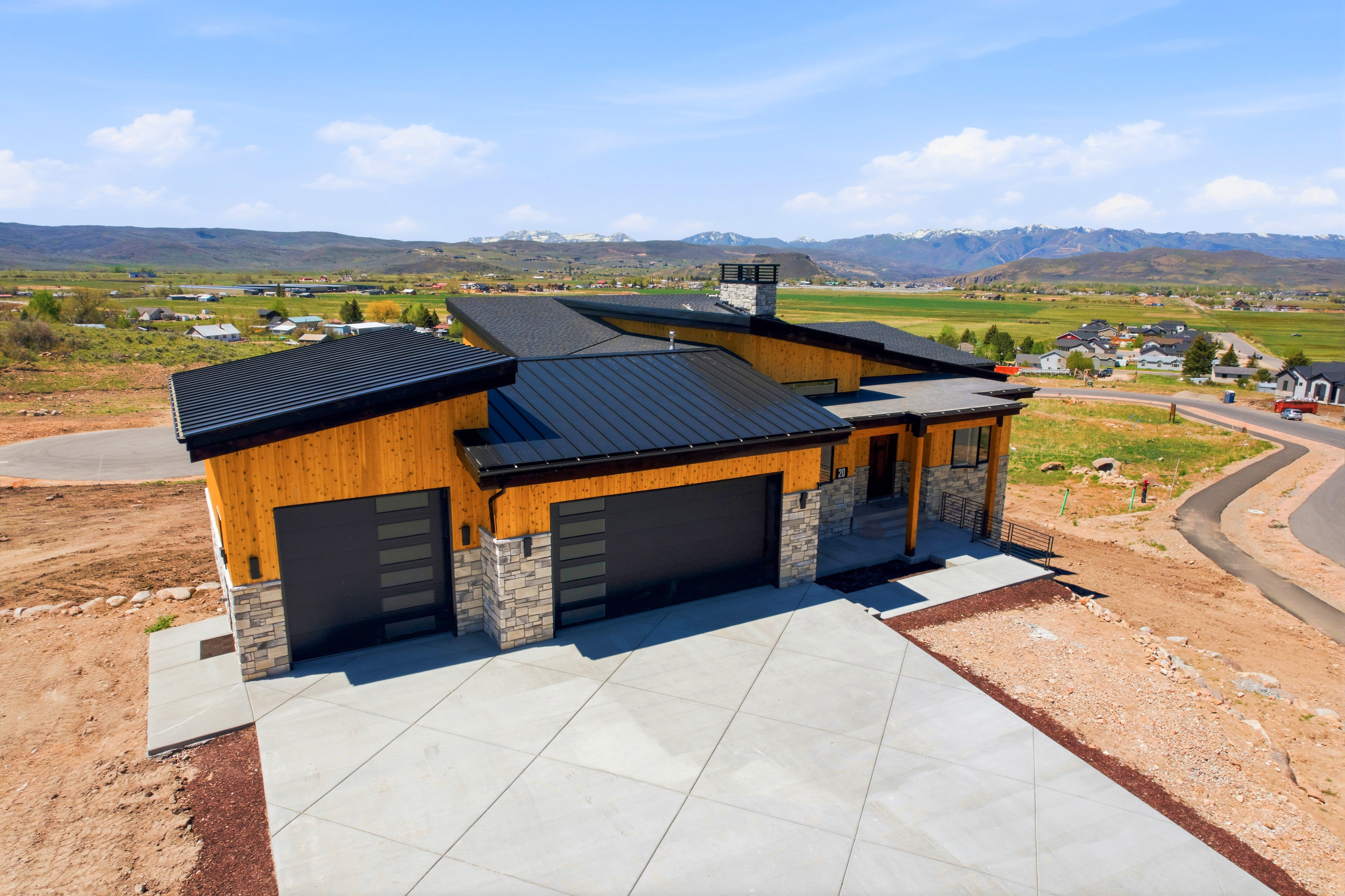 Modern single-level residence featuring a multi-tone wood-paneled exterior and stone accents