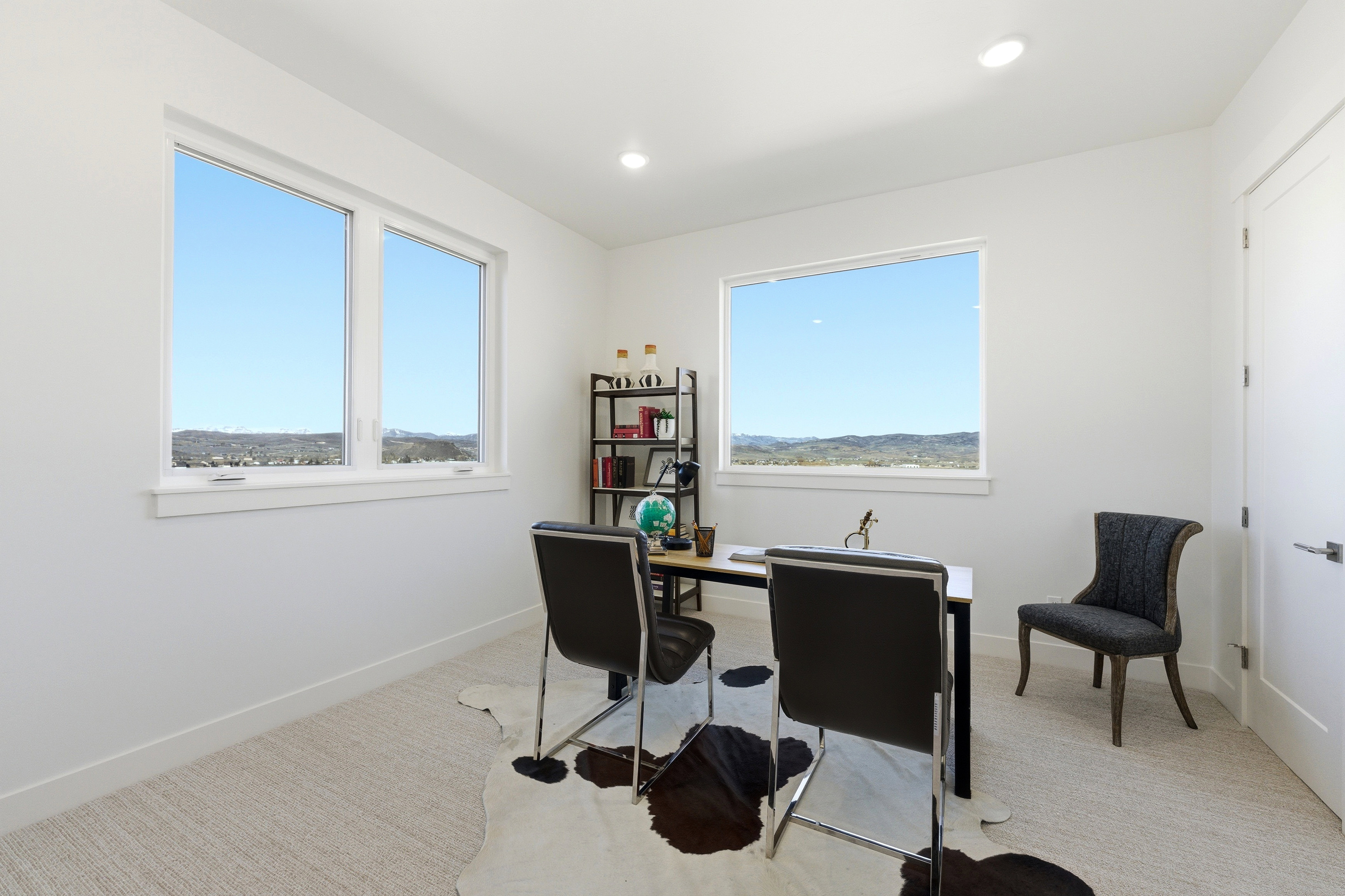 Bright room featuring two large windows, recessed lighting, and light-toned carpet flooring