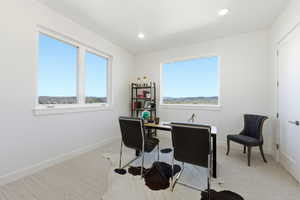 Bright room featuring two large windows, recessed lighting, and light-toned carpet flooring