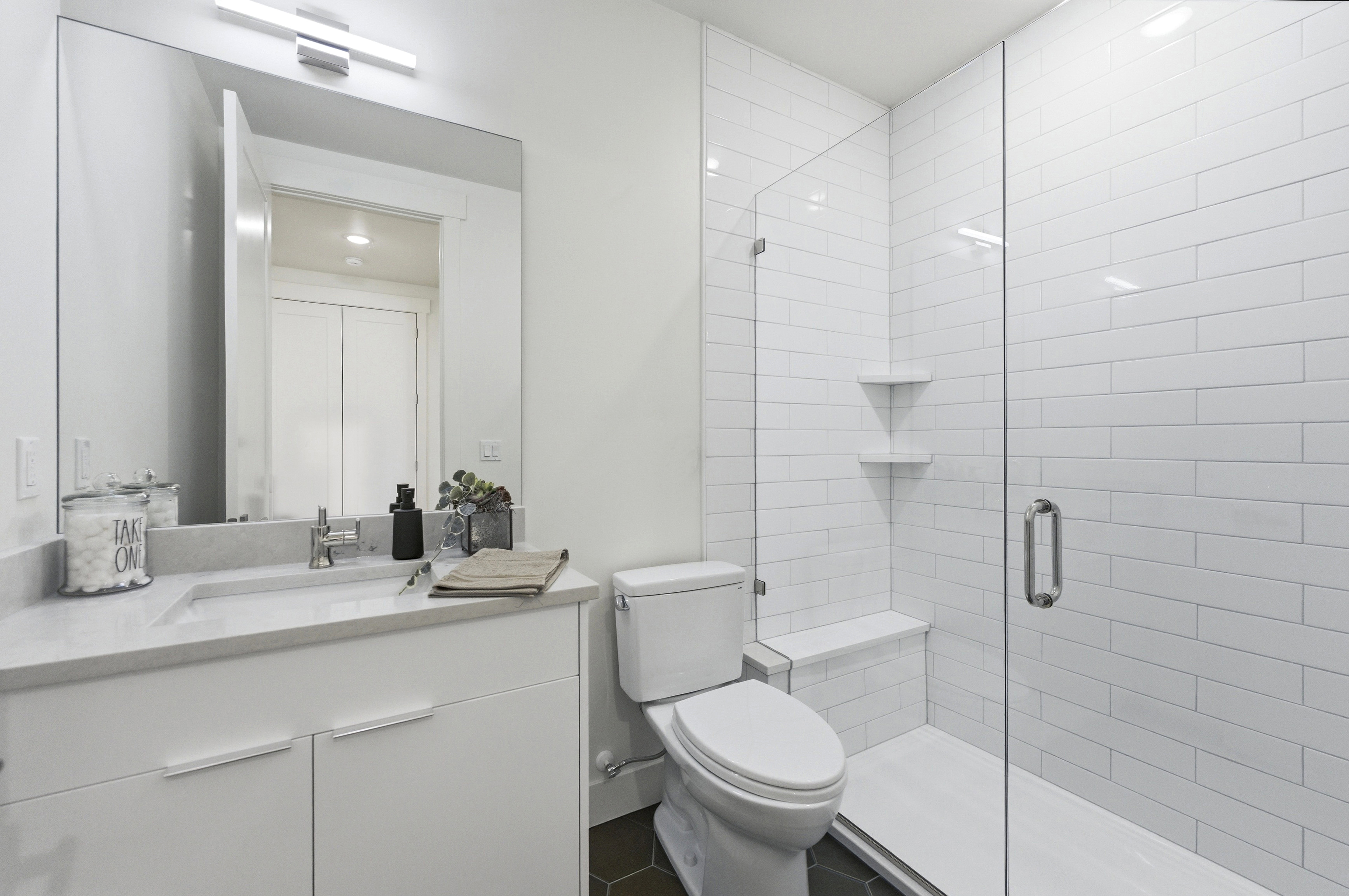 Bathroom featuring a glass-enclosed shower with subway tile surround and built-in bench