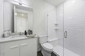 Bathroom featuring a glass-enclosed shower with subway tile surround and built-in bench
