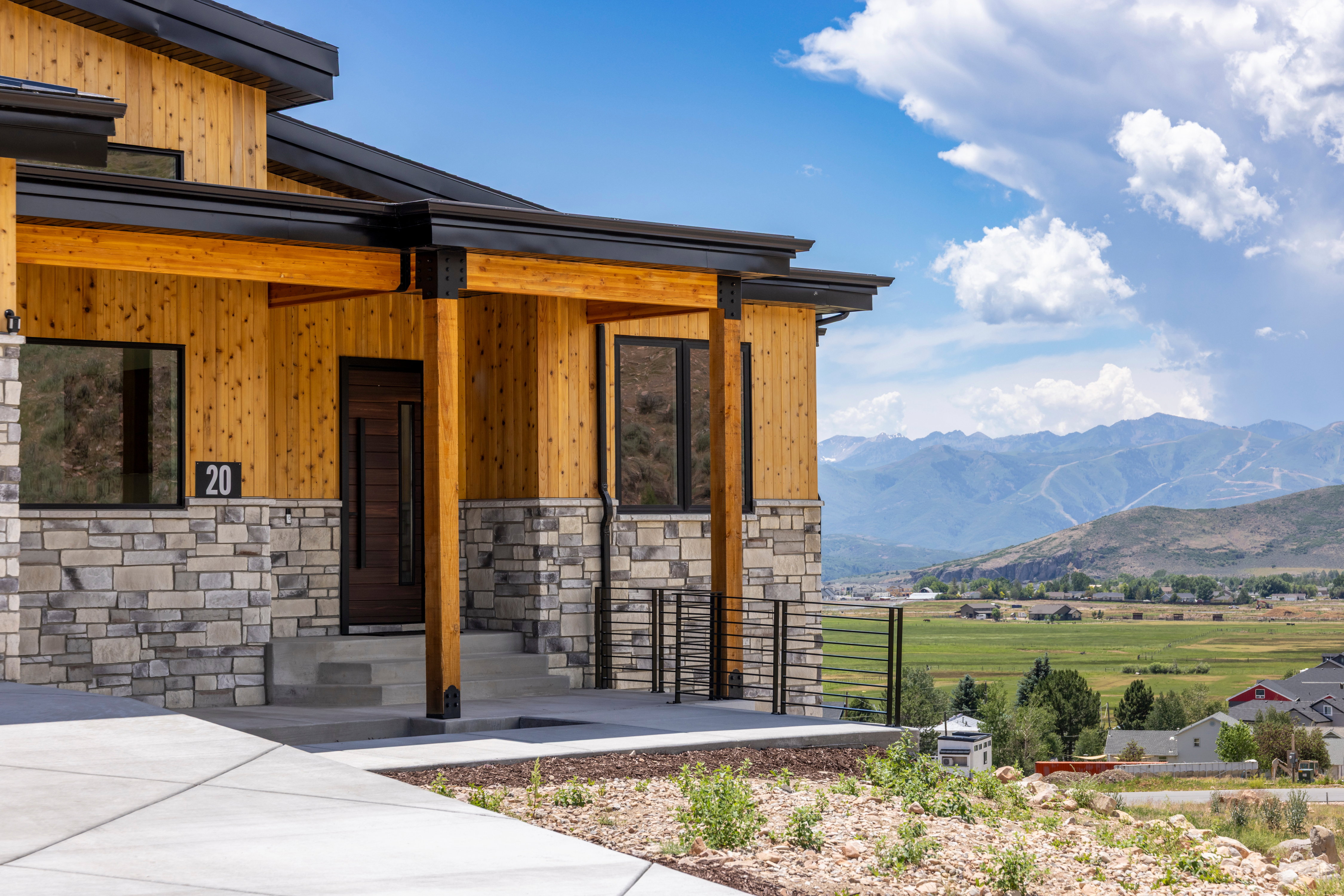 Modern exterior featuring stone veneer and vertical wood siding