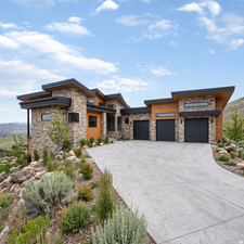 Contemporary architectural design featuring a stone and wood siding exterior with multiple flat rooflines. Rendering using AI as home is under construction.