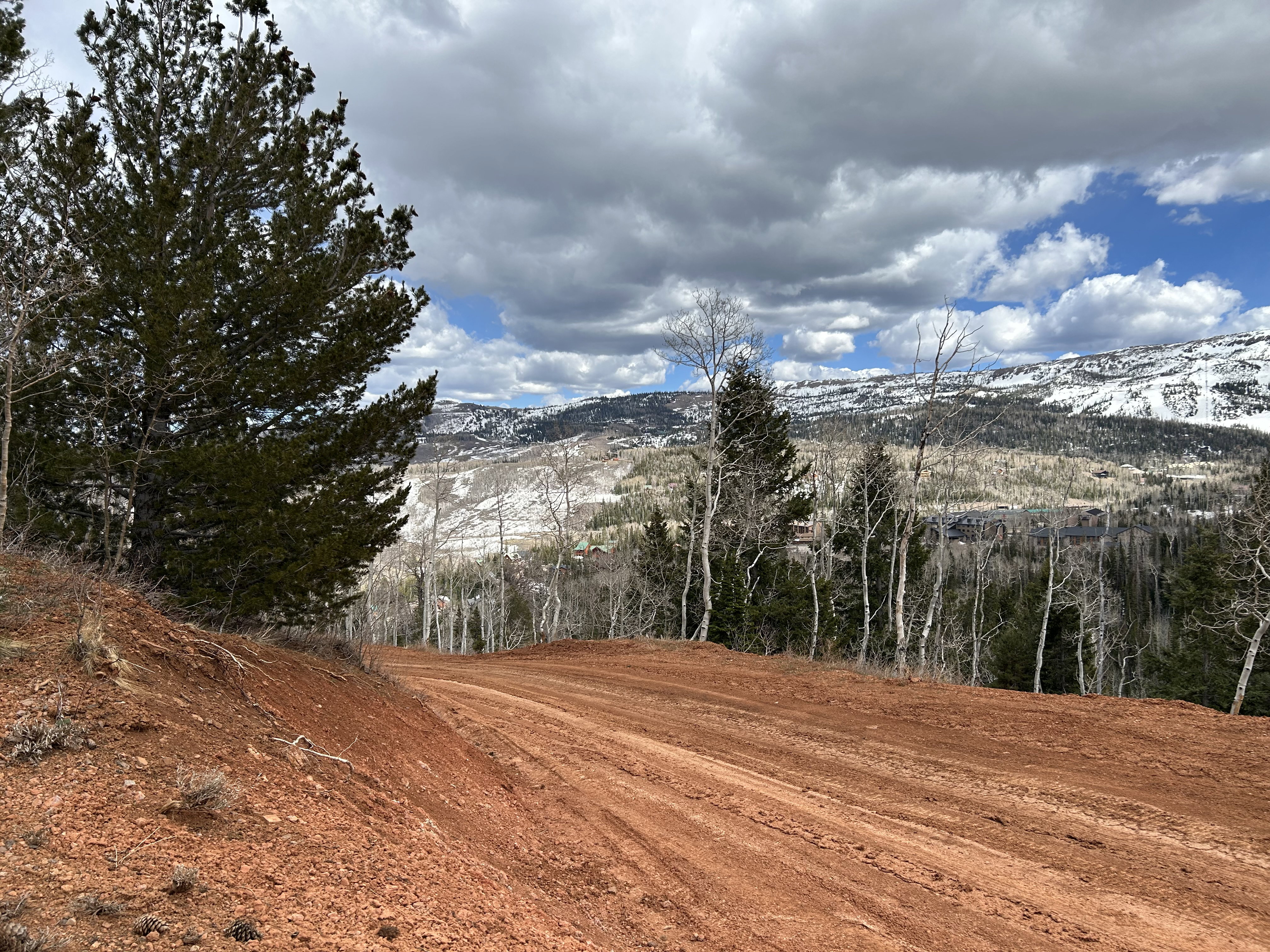 Expansive land parcel featuring rich red soil and a prepared level area