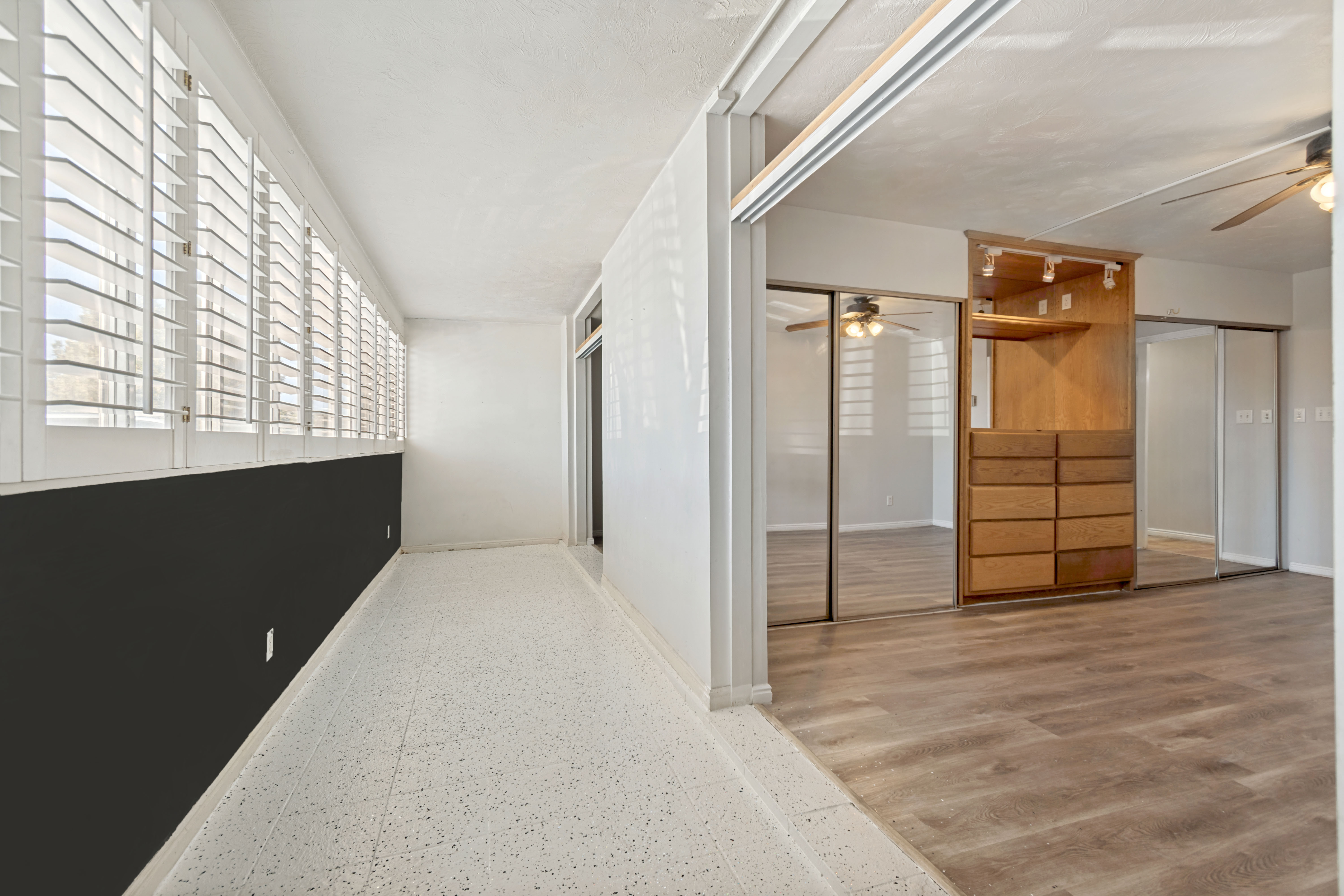 Sunroom featuring white plantation shutters and terrazzo flooring