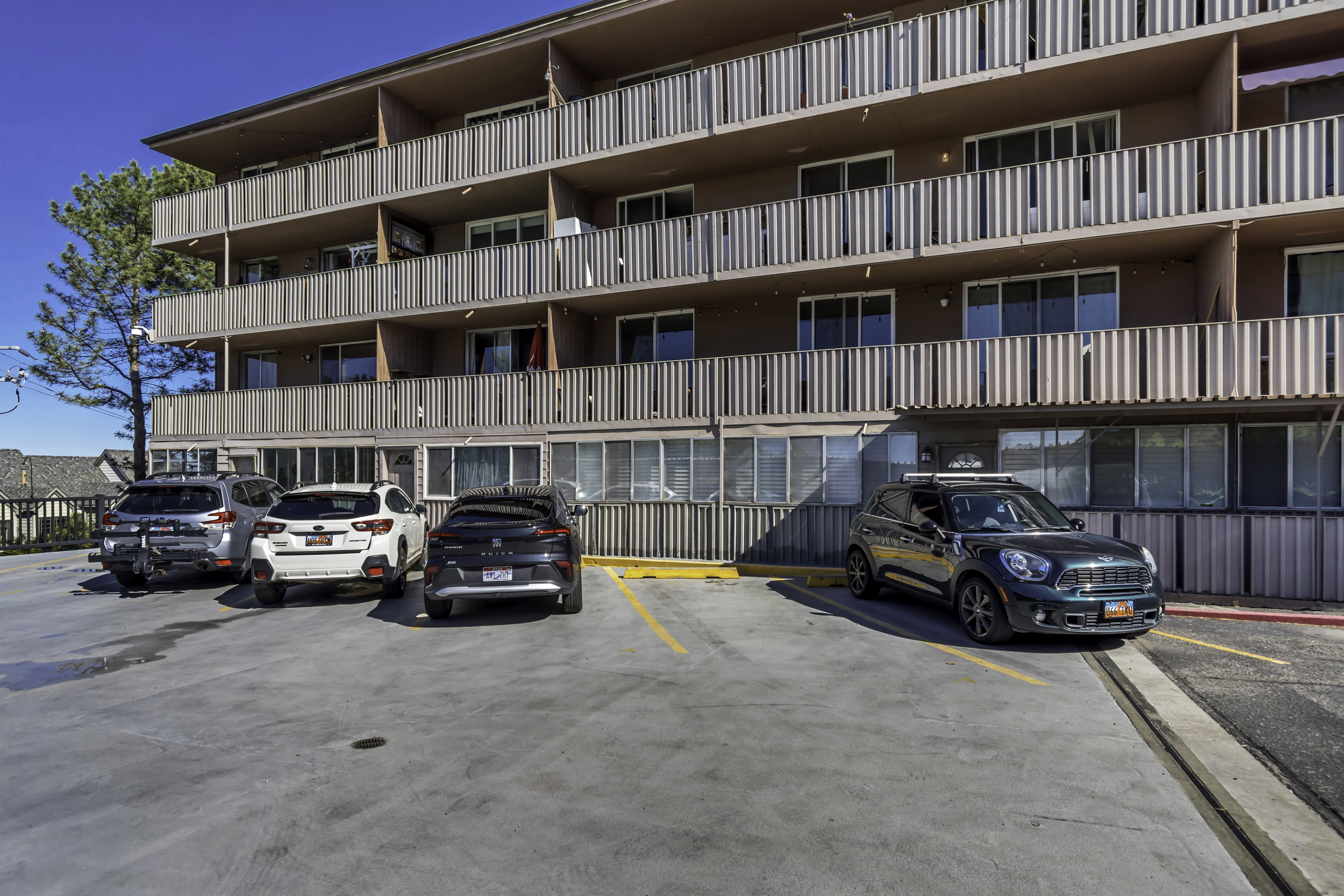 Multi-story building exterior with individual balconies featuring vertical panel railings
