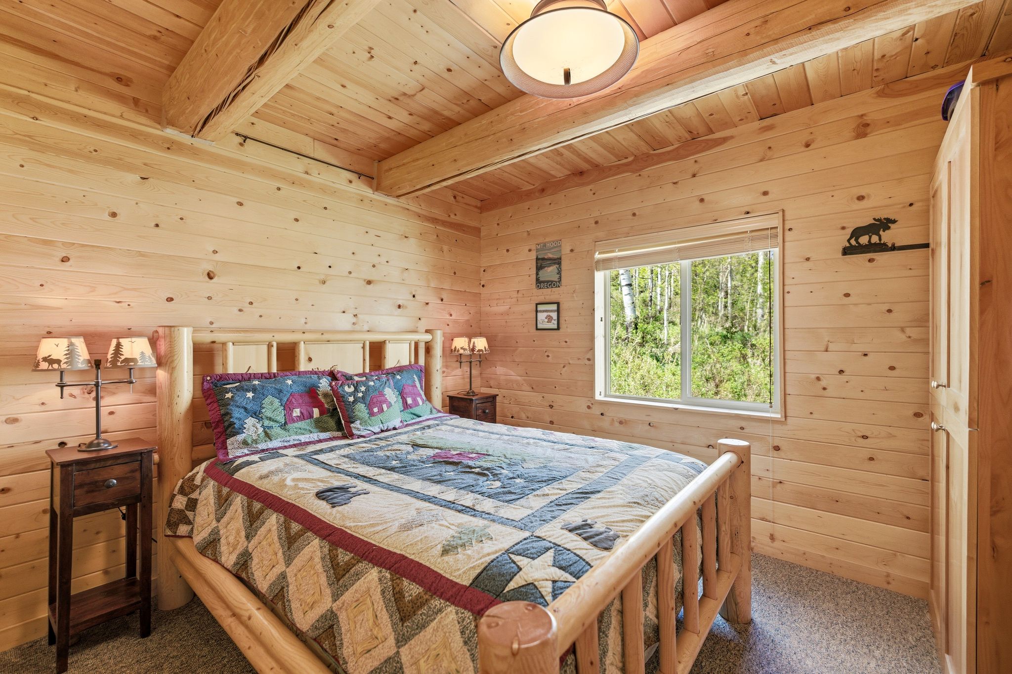Wood-paneled room featuring exposed ceiling beams and a large window