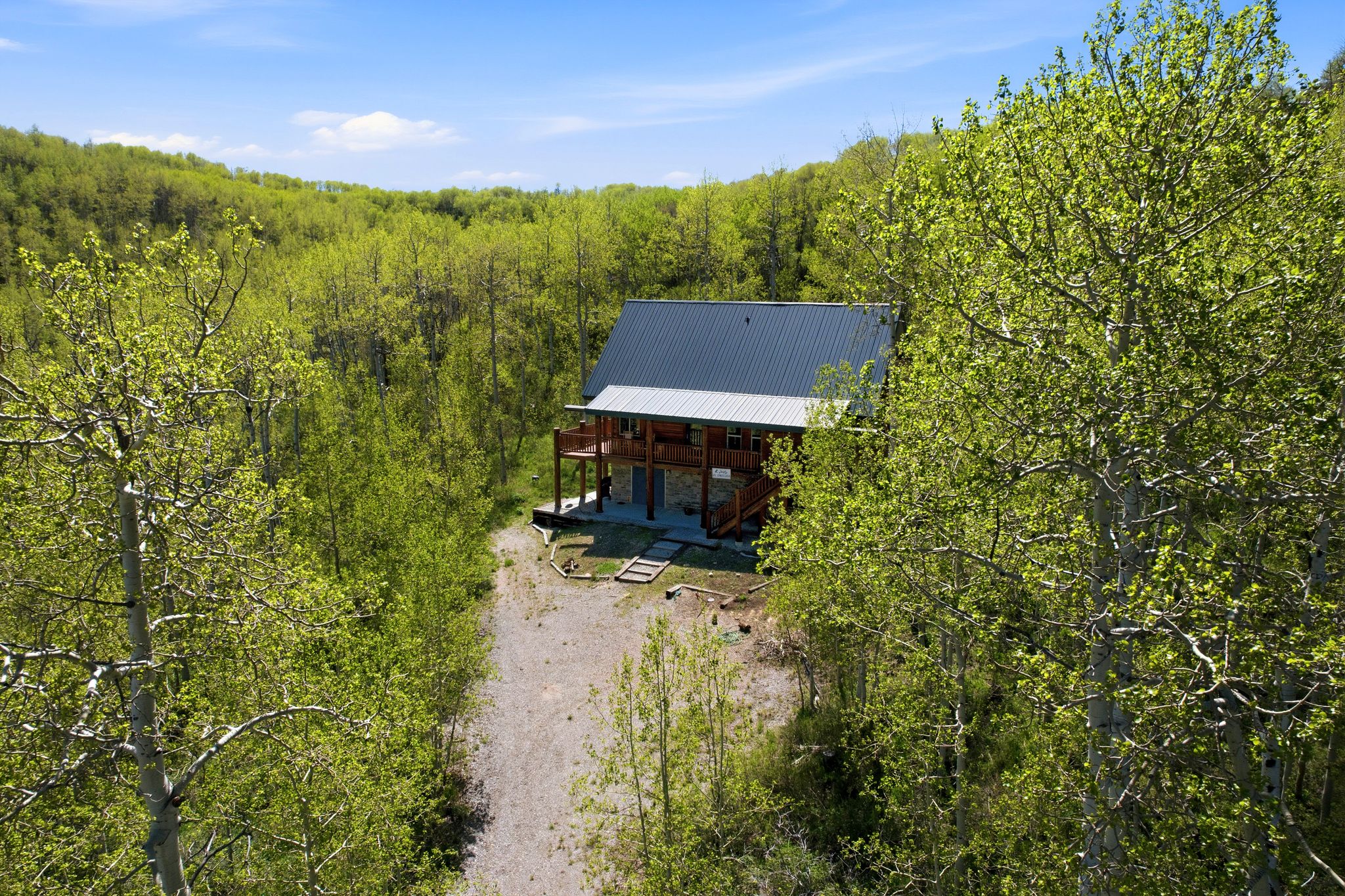 Log cabin exterior with an expansive surrounding landscape of mature trees