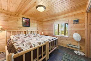 Wood-paneled interior featuring a wood-finish ceiling and walls, a casement window, and dark tone flooring