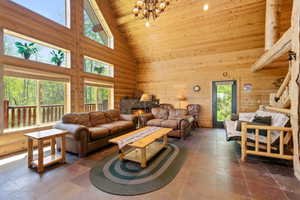 Vaulted wood-paneled ceiling with exposed log beams and a wrought iron chandelier