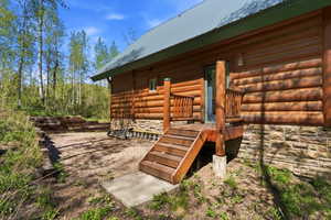 Log-sided exterior with a light green metal roof