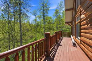 Expansive log-sided exterior with a natural wood deck