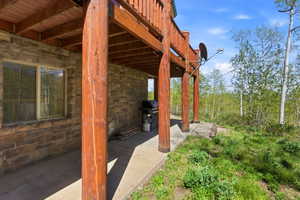 Covered patio with stone veneer siding and exposed wood beam supports