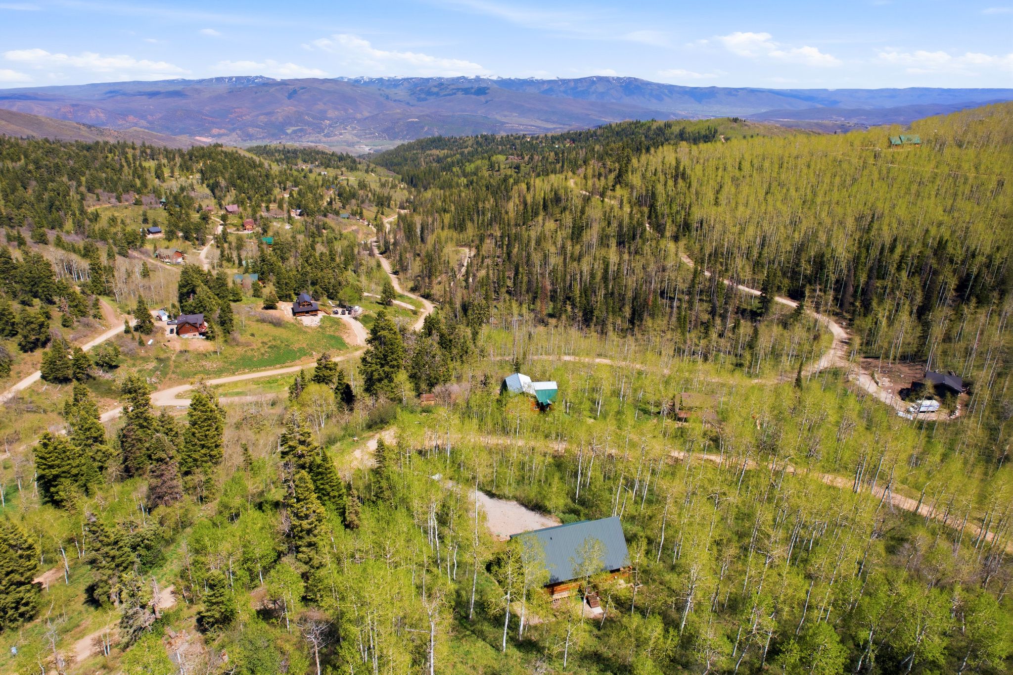 Mountainous landscape with expansive tree coverage and scattered residential structures