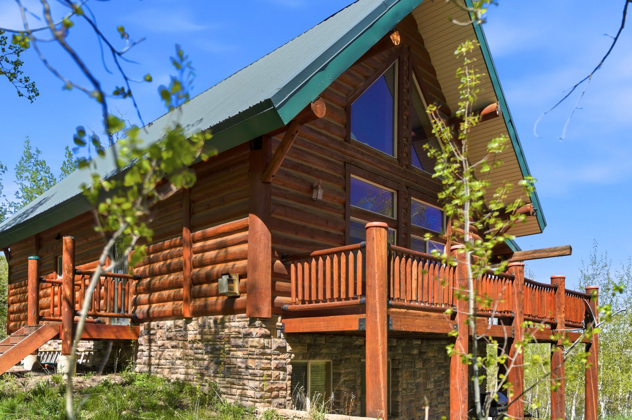 Log cabin style exterior with a metal roof and large A-frame windows