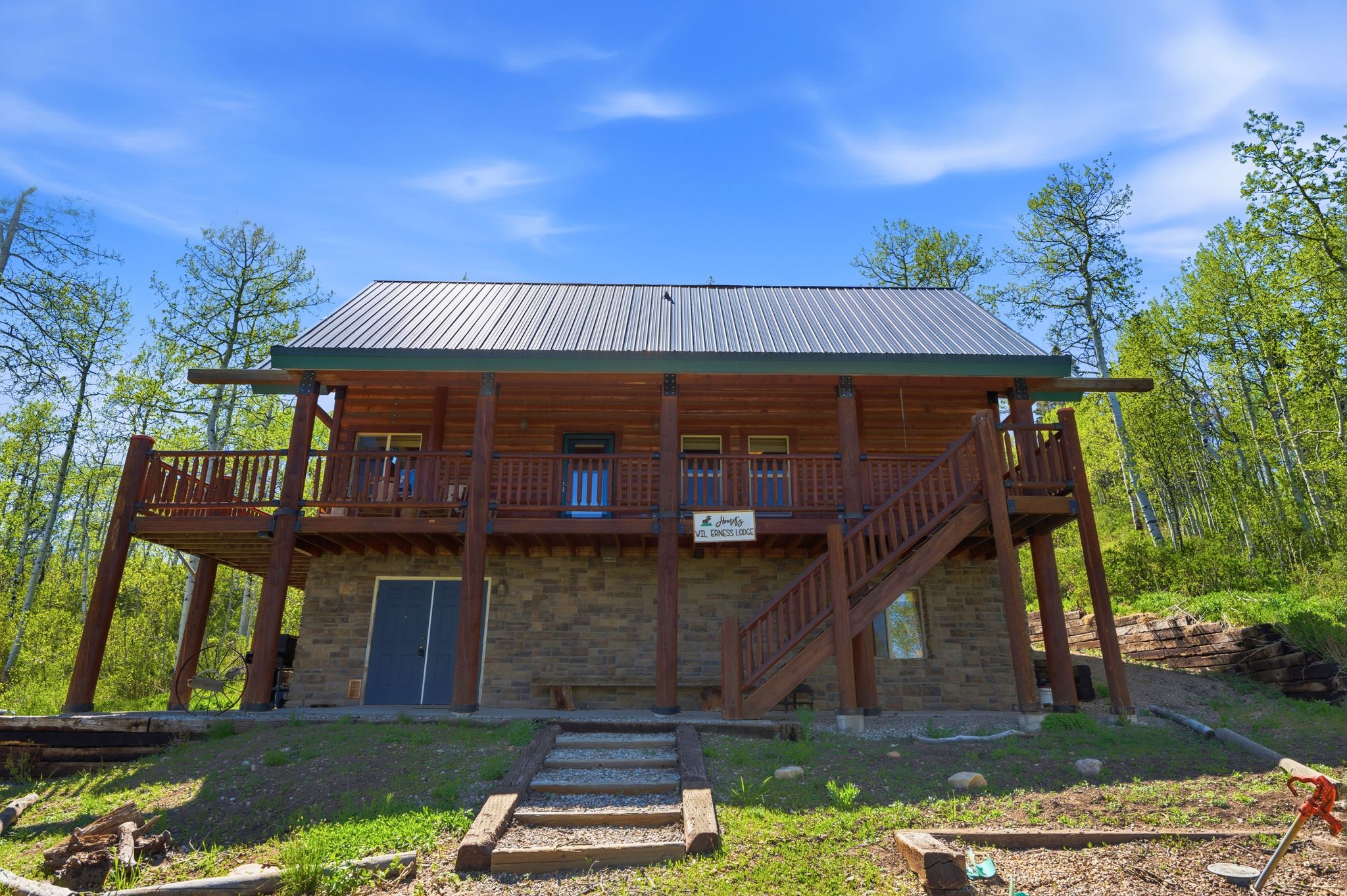 Log cabin exterior with a metal roof and stone foundation