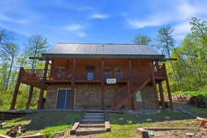 Log cabin exterior with a metal roof and stone foundation
