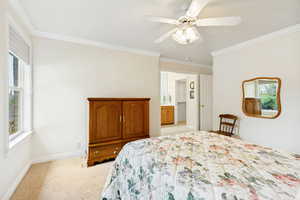 Bright interior space featuring a window with blinds, a ceiling fan with integrated lighting, and crown molding